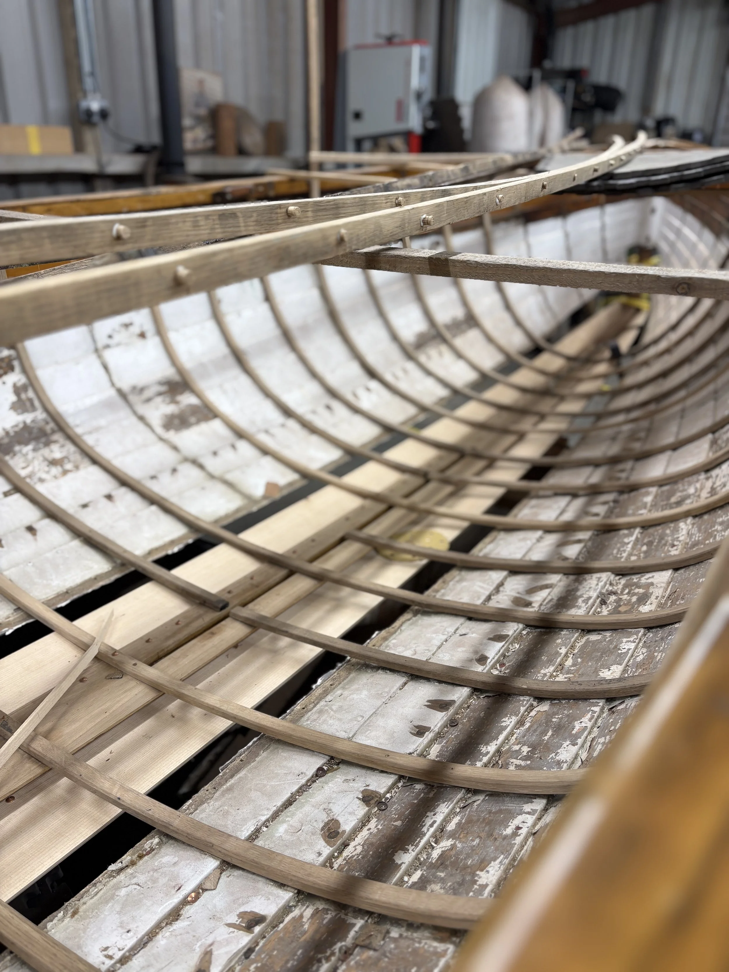Wooden boat ribs under construction in a workshop.
