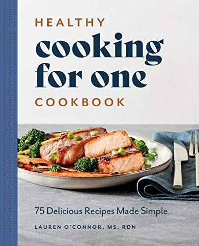 Cover of 'Healthy Cooking for One' cookbook showing a plate with cooked salmon and broccoli, and a napkin with silverware.