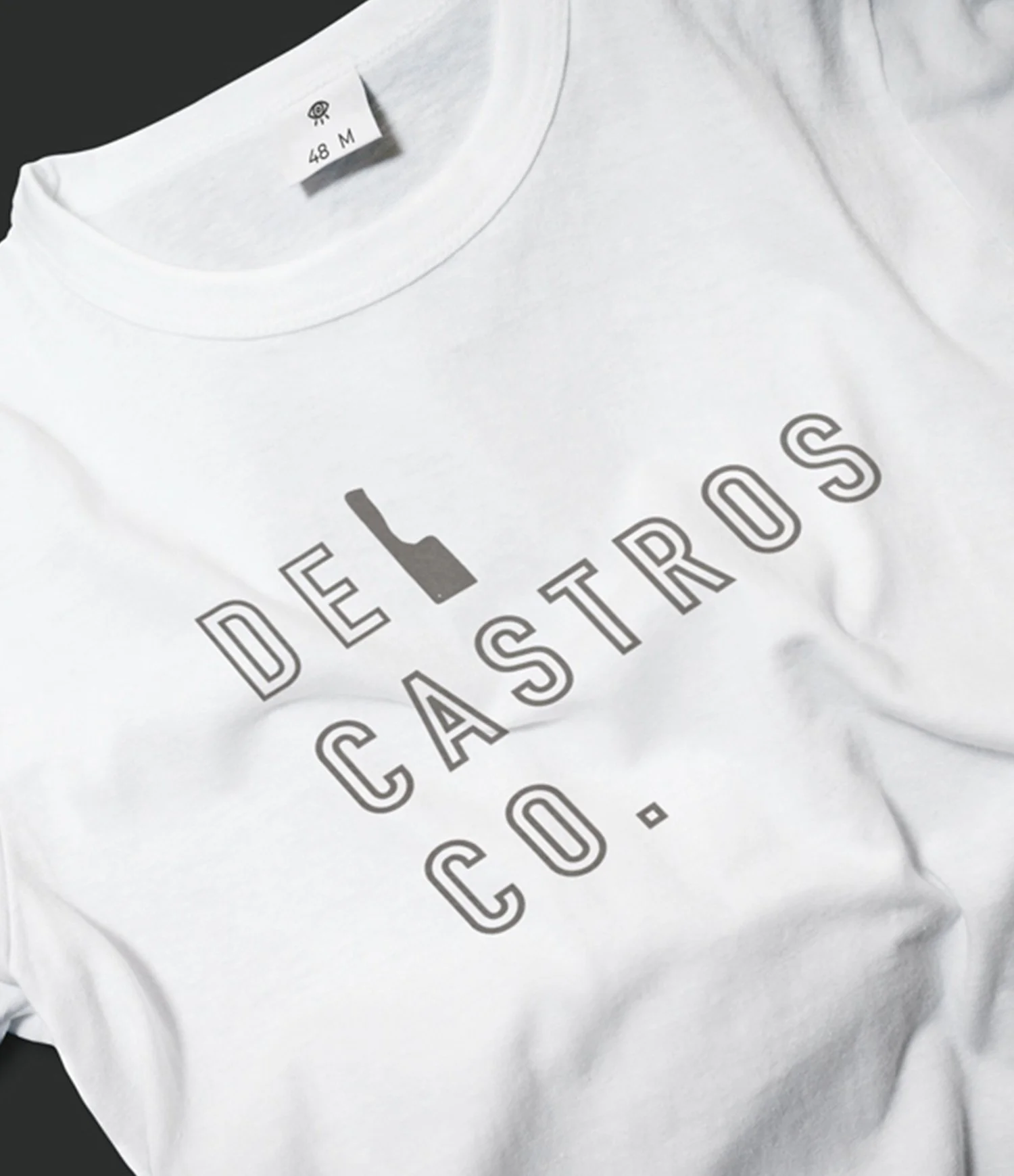 White T-shirt with the text 'DEI CASKTROS.CO.' and an image of a bottle replacing the letter 'I' in 'DEI'.