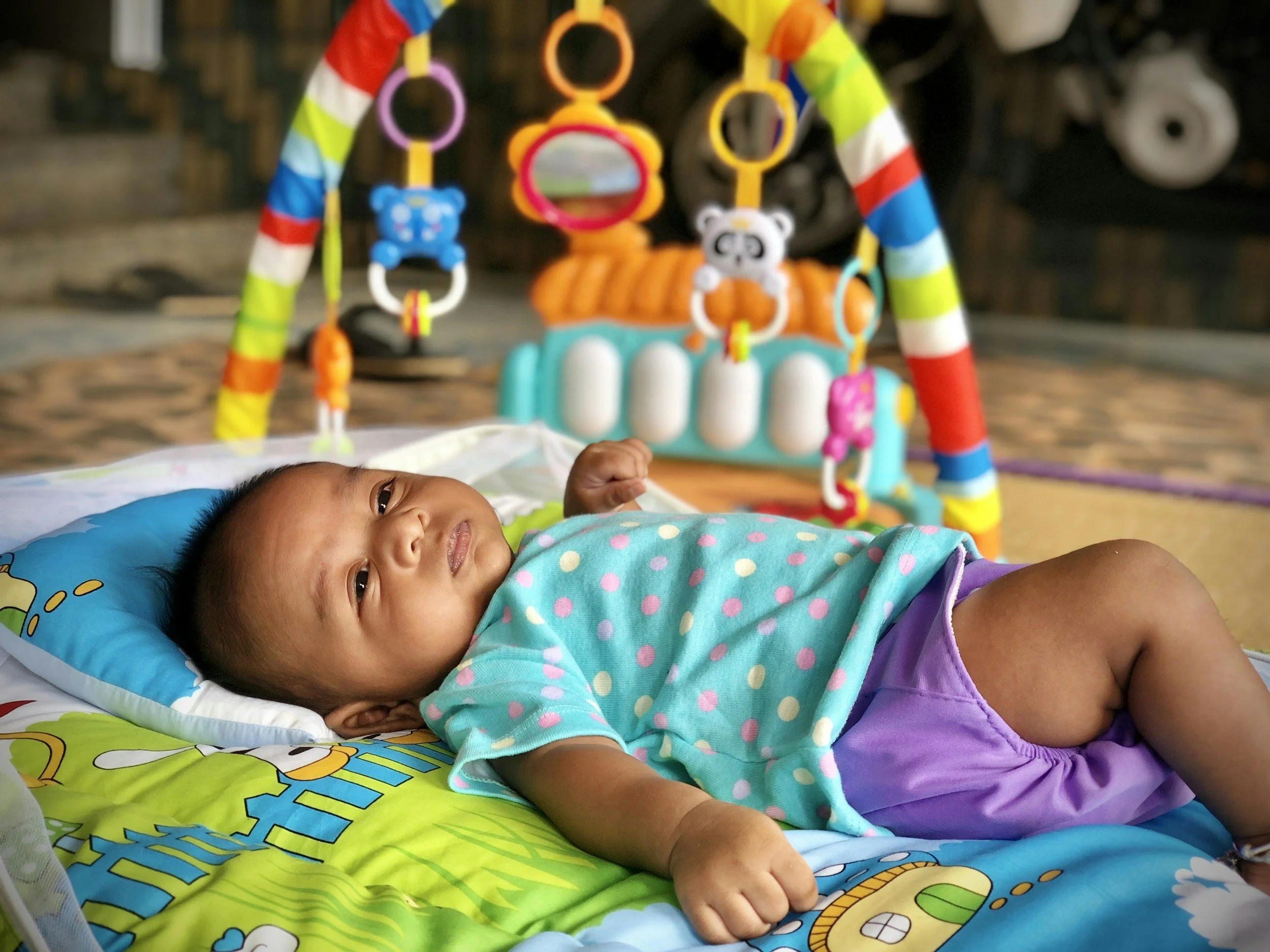 Ein schlafendes Baby liegt neben seinem Spielzeug