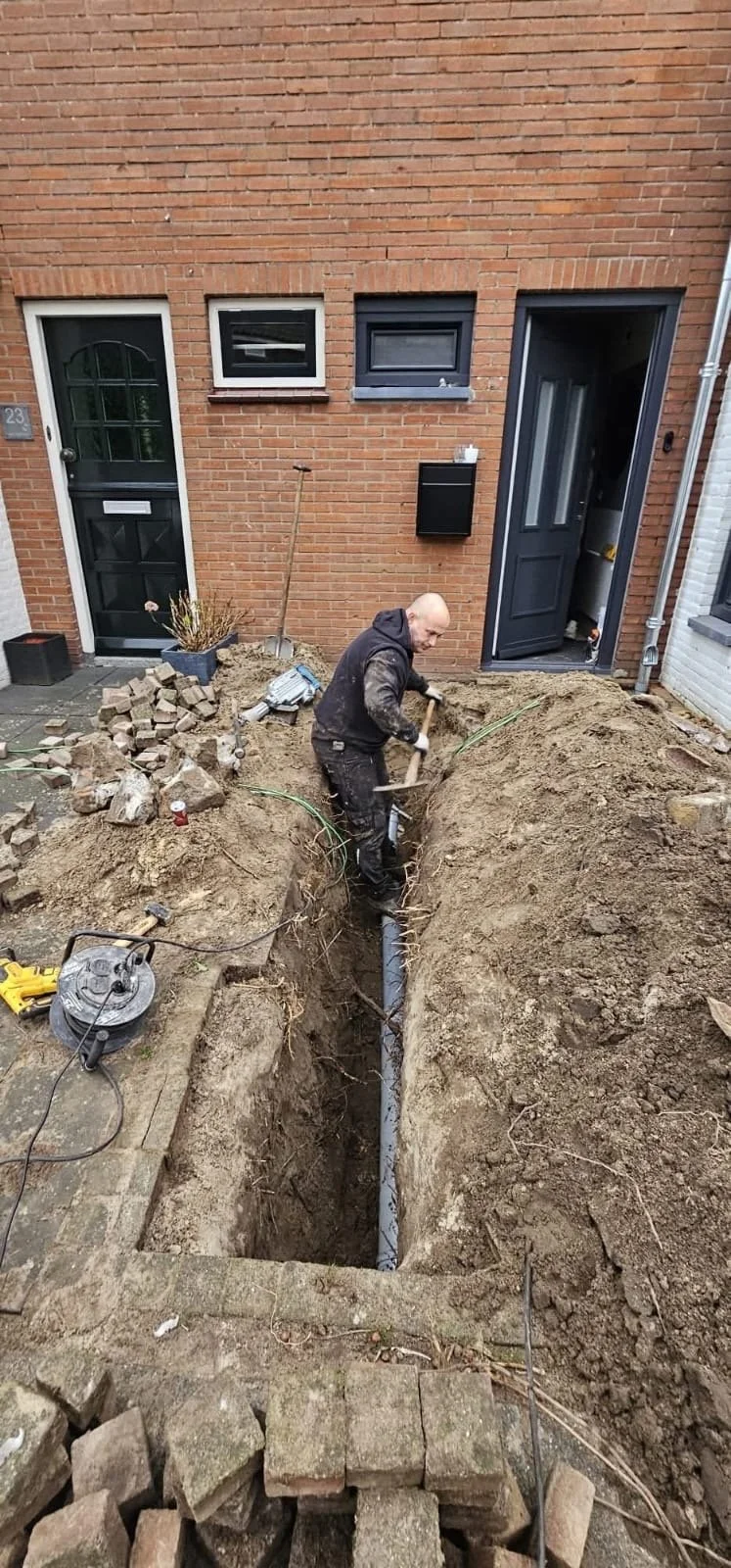 Medewerker van DKM de Rioolspecialist graaft een sleuf voor rioolaanleg en rioolvervanging bij een woning in Breda