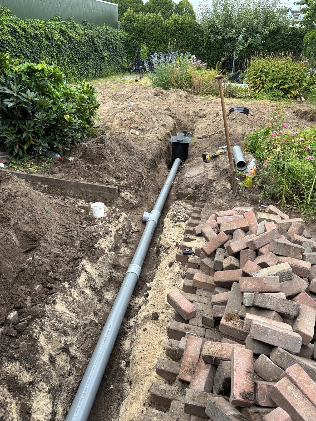 Verzakte rioolleiding vervangen in een achtertuin in Dordrecht