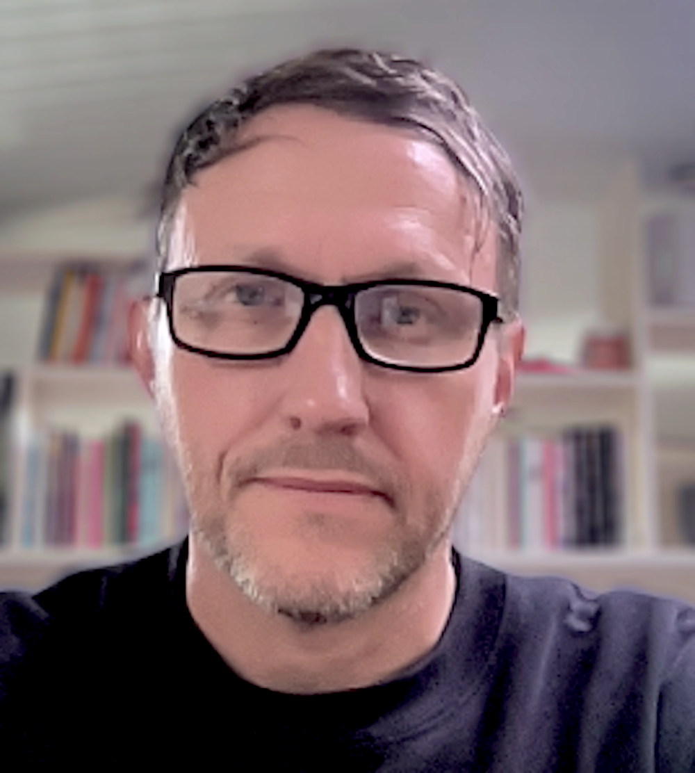 image of Benjamin Cook, a white middle-aged man wearing glasses