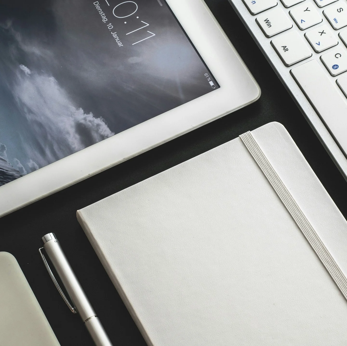 Flatlay of an iPad, notebook and pen