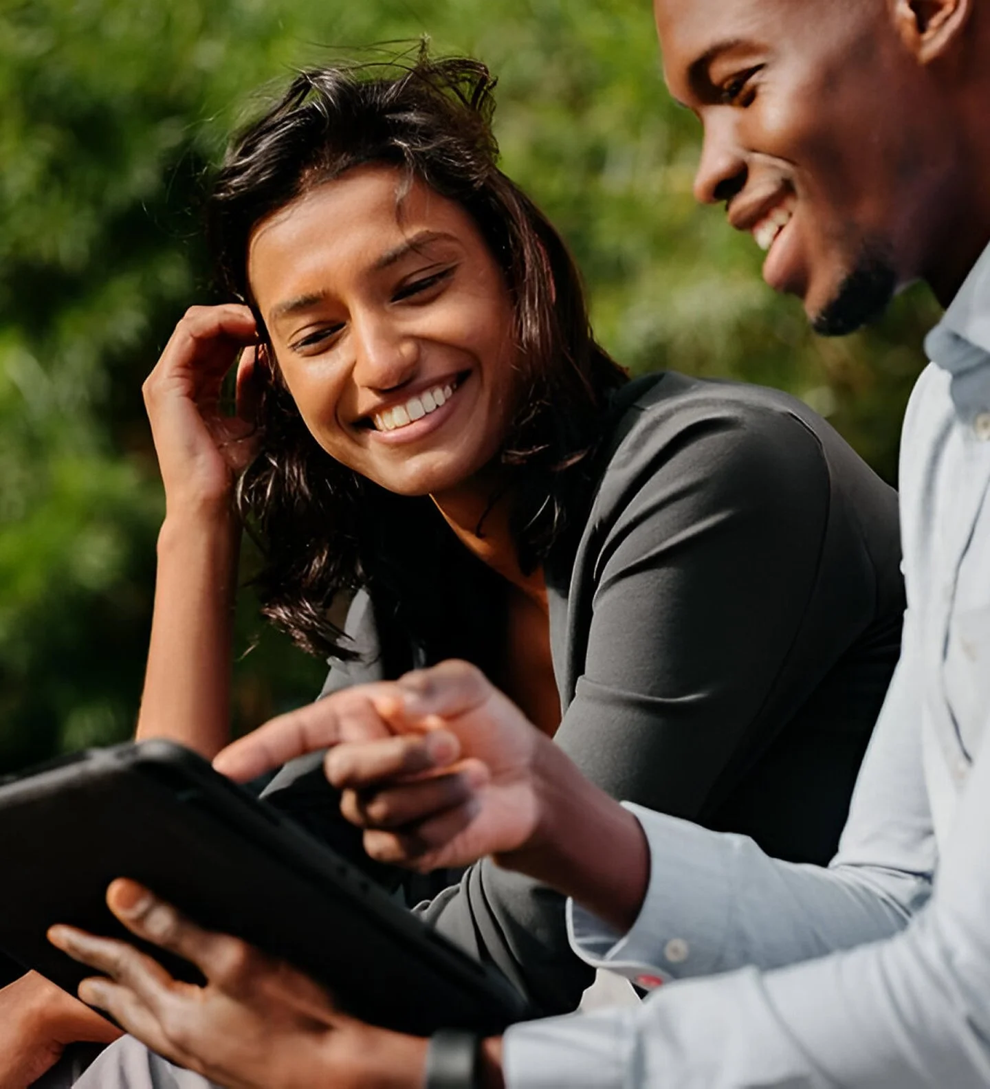 A man showing a woman something on his iPad