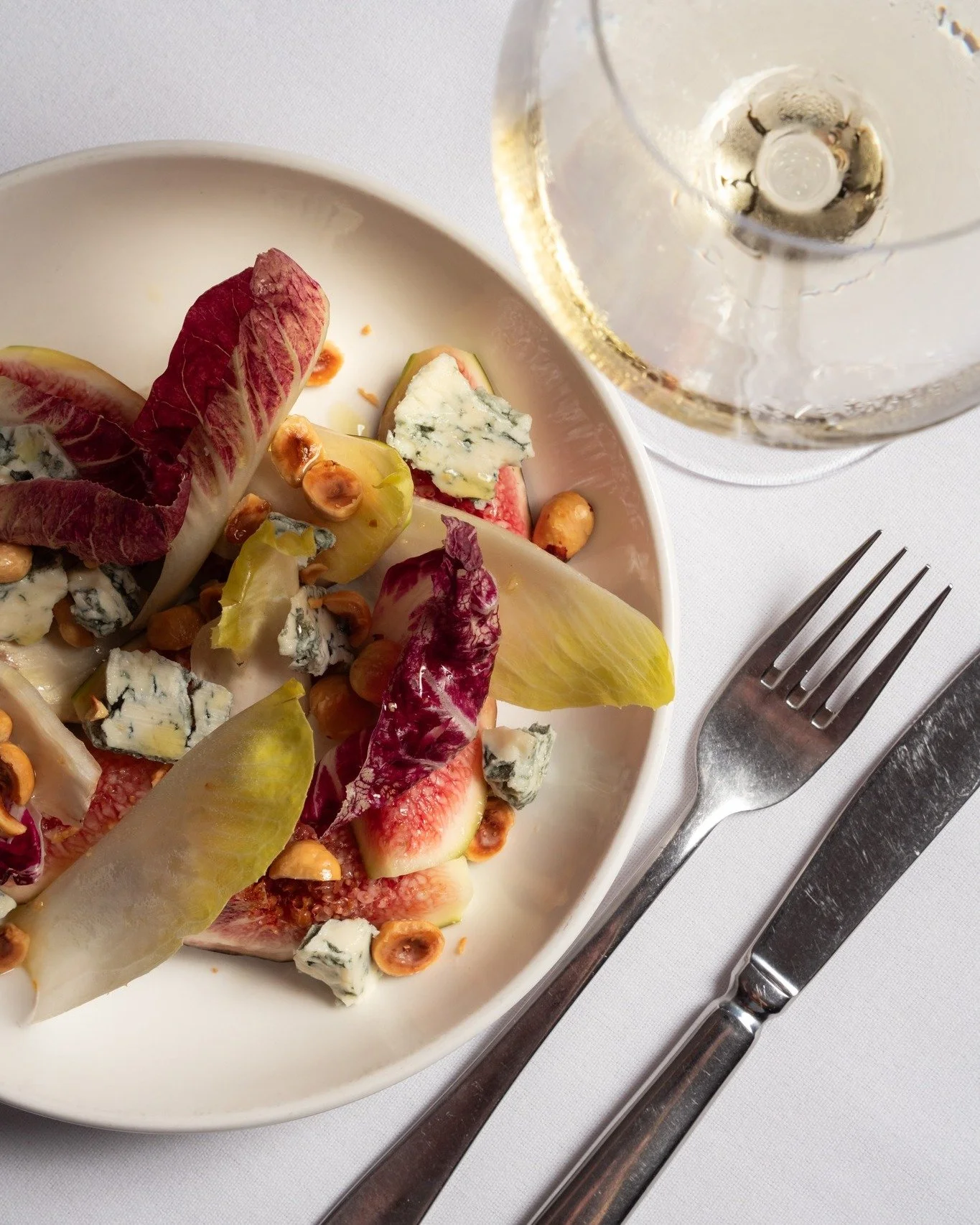 A simple Autumn salad of fresh figs, bitter leaves, roasted hazelnuts &amp; gorgonzola piccante. A glass of Vermentino to accompany, and all is right in the world.

📸 @isabellagwild