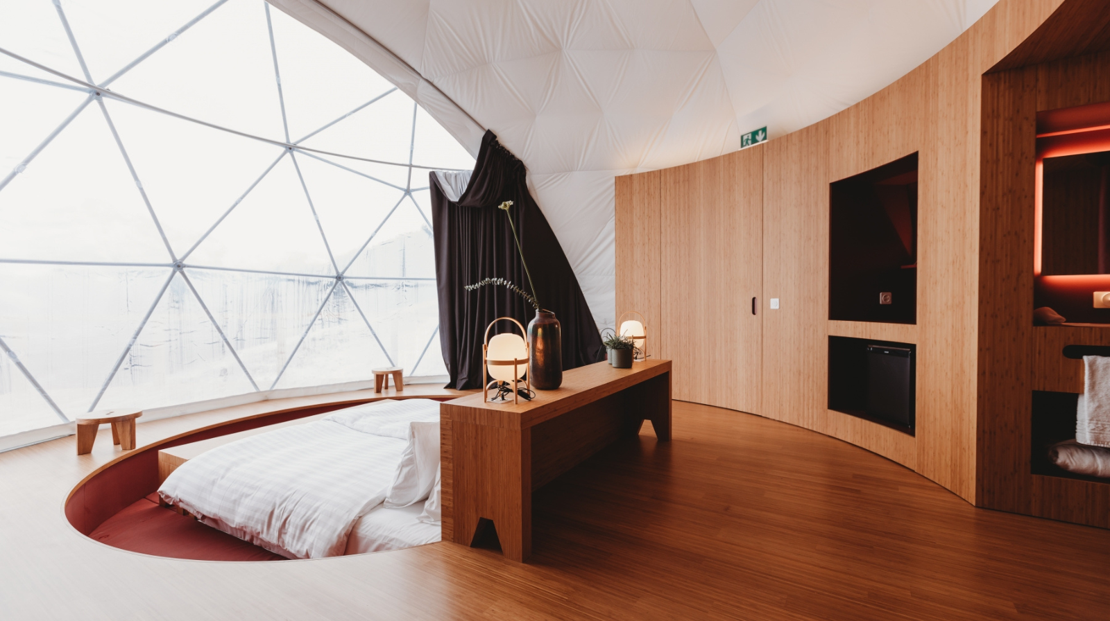 Minimalist interior of geodesic dome pod at Whitepod with mountain views through panoramic windows