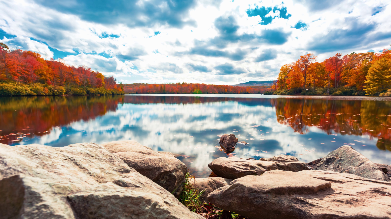 Fall foliage reflected in lake near Asheville North Carolina with Blue Ridge Mountains in background