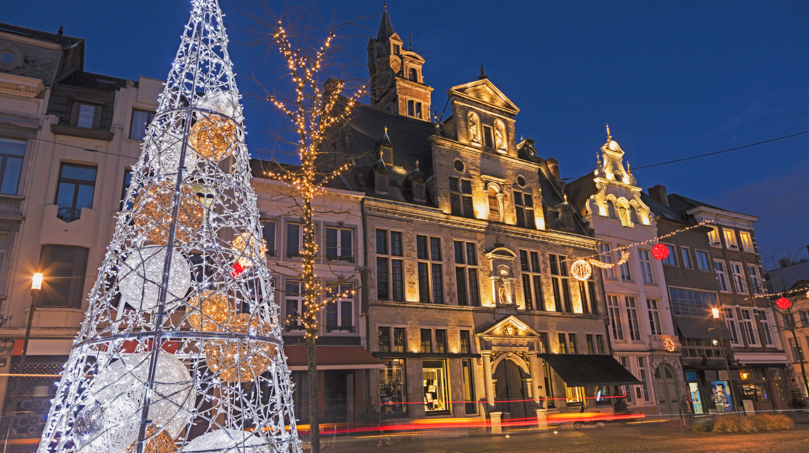 Antwerp Christmas market at night with illuminated tree and historic Grote Markt guildhalls in Belgium