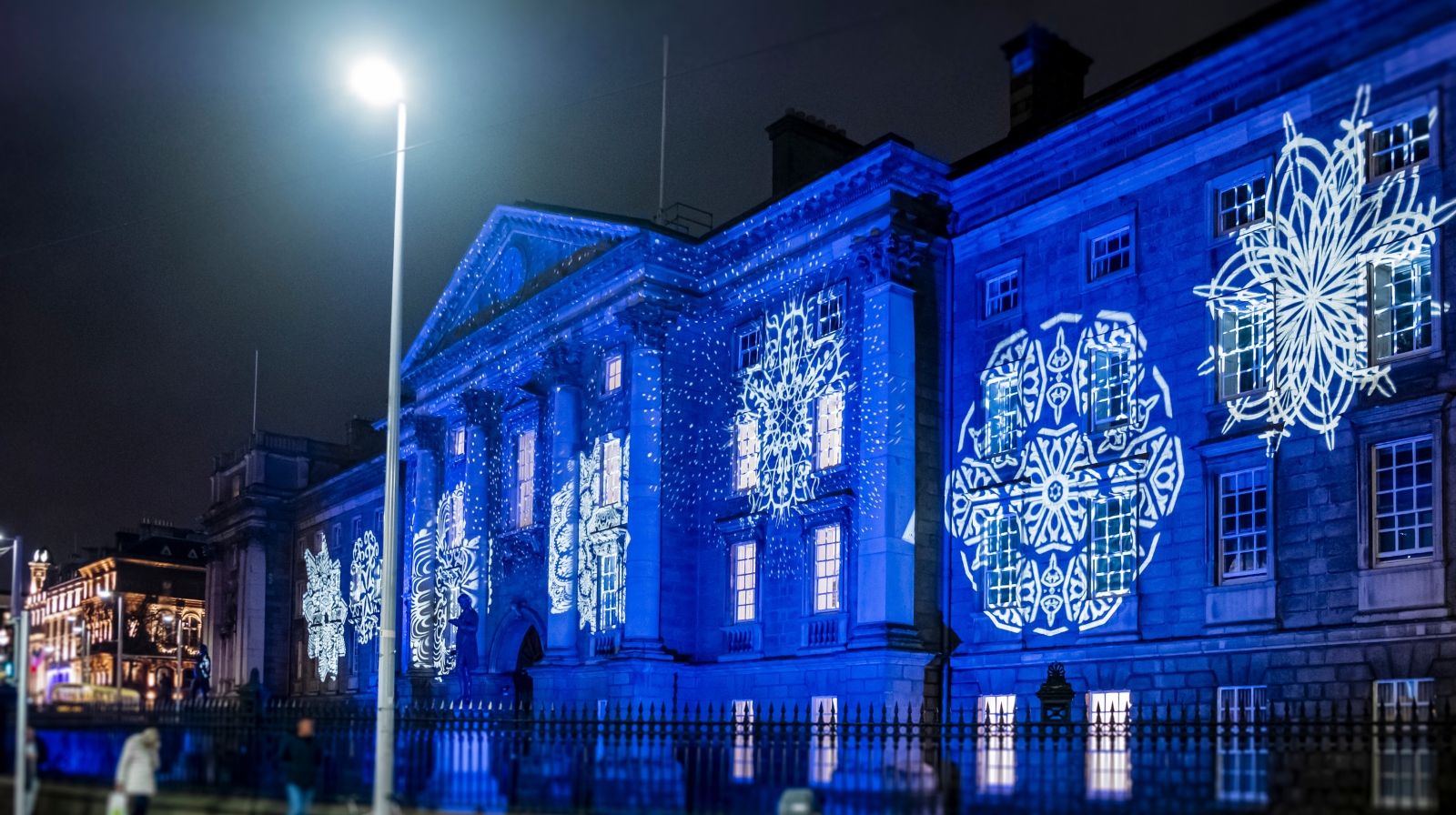Dublin Trinity College illuminated with blue Christmas light projections at night in Ireland