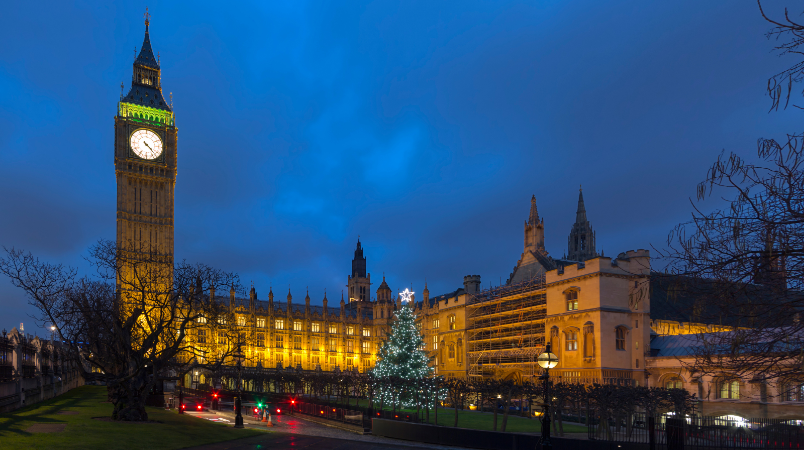London Big Ben clock tower and Westminster Parliament with Christmas tree at dusk, United Kingdom
