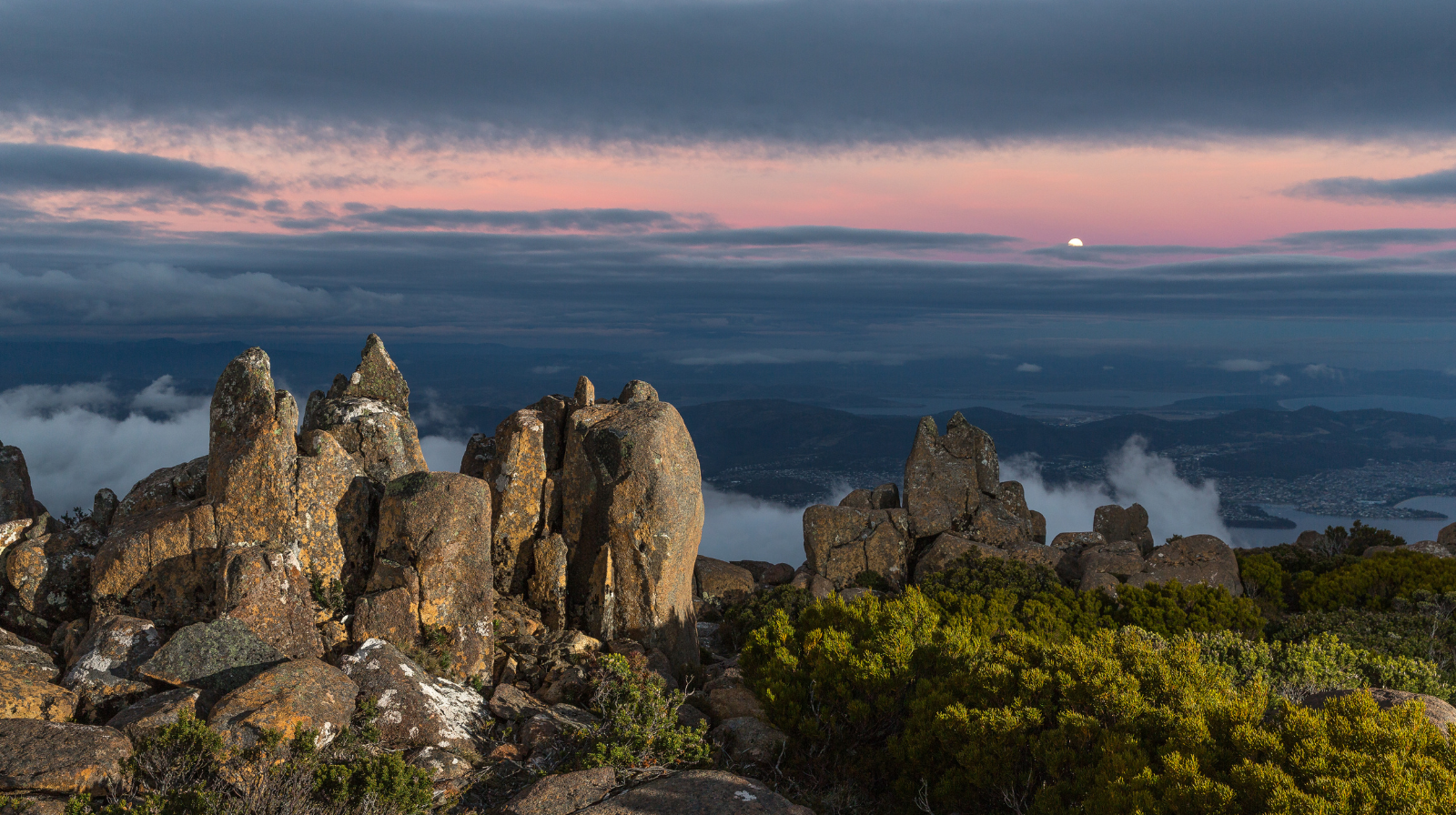 Dramatic rocky peaks of Mount Wellington overlooking Hobart and the Derwent River at sunset in Tasmania, Australia