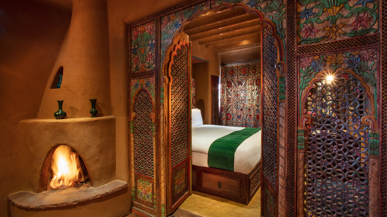 Ornate suite with hand-painted Moroccan tiles, kiva fireplace, and global textiles at Inn of The Five Graces