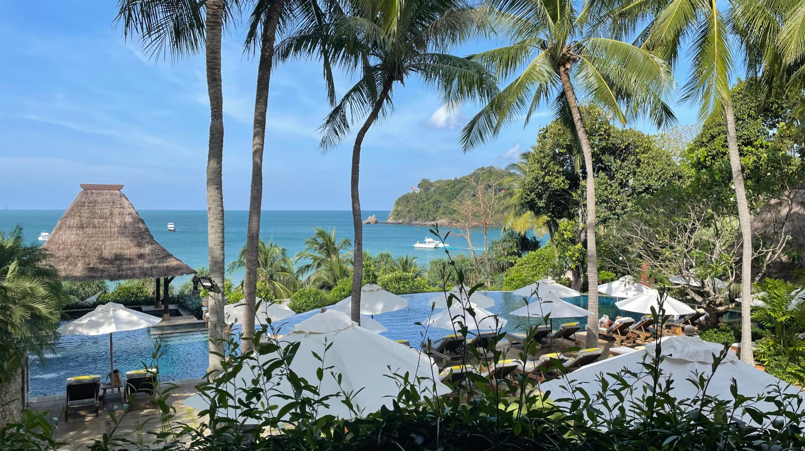 Tropical pool and beachfront at Pimalai Resort and Spa, Koh Lanta, Thailand, surrounded by palm trees, lush gardens, and views of the Andaman Sea.