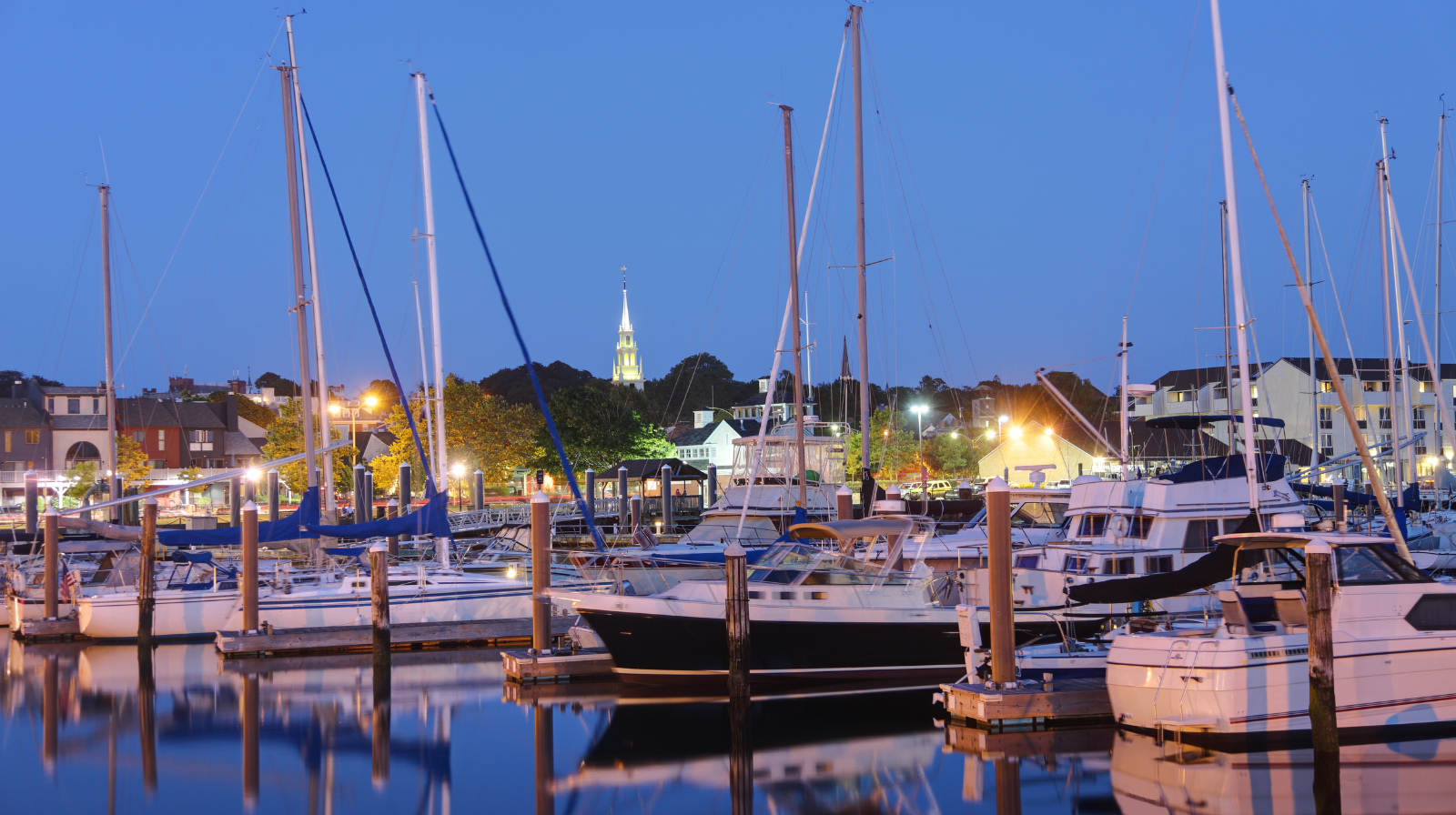 Newport Rhode Island harbor with sailboats and historic church steeple at evening during winter