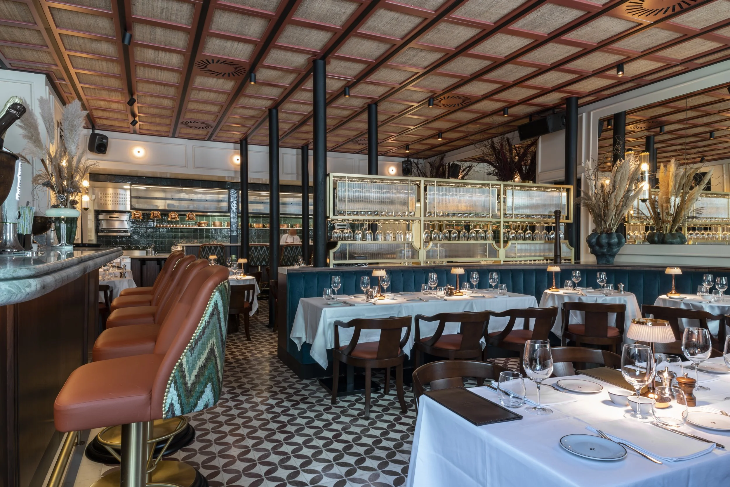 Daavero restaurant interior in Lisbon, Portugal—modern dining space with elegant bar seating, patterned tile floors, stylish decor, and tables set with white linens and glassware, reflecting a sophisticated atmosphere for upscale dining.