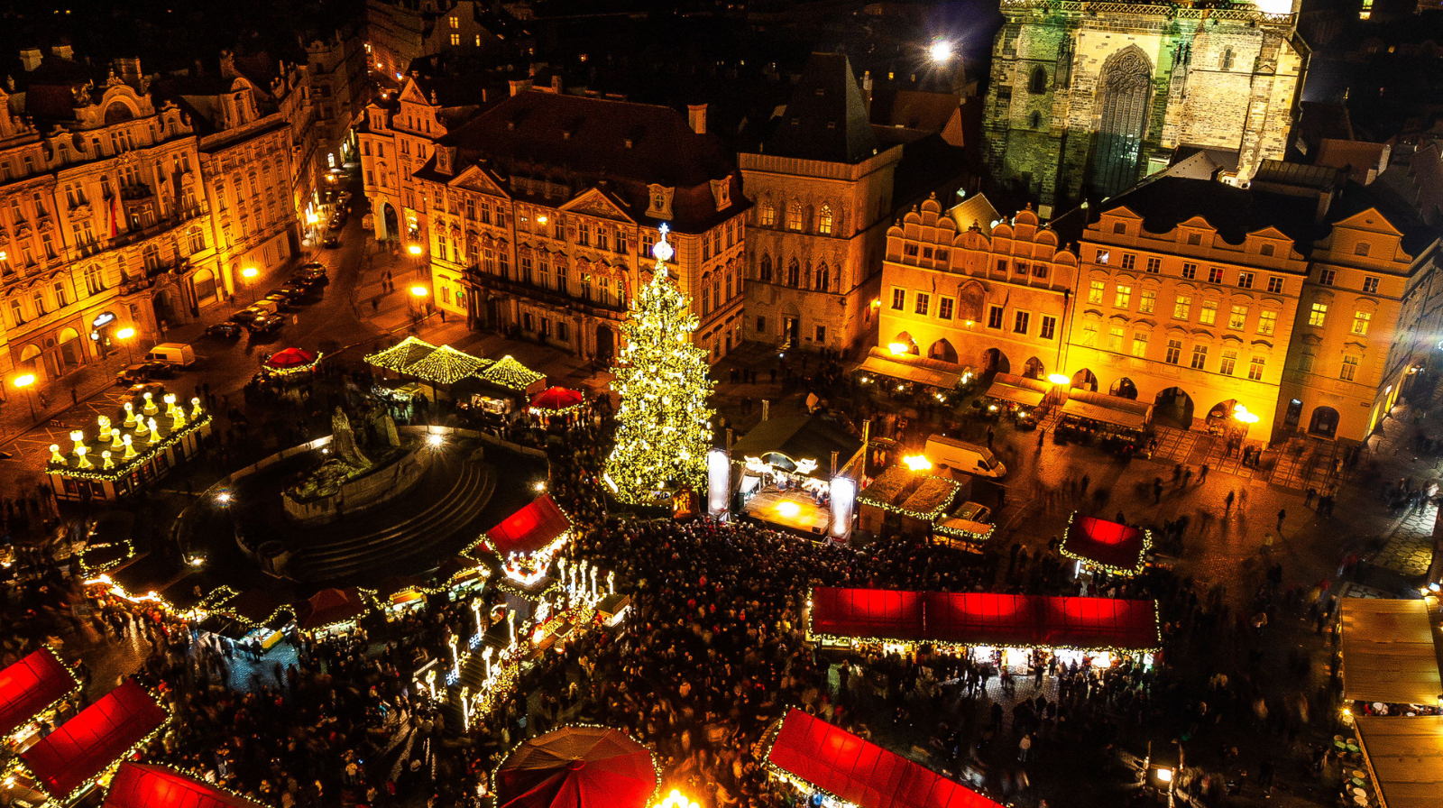 Prague Old Town Square Christmas market with illuminated tree and historic buildings at night, Czech Republic