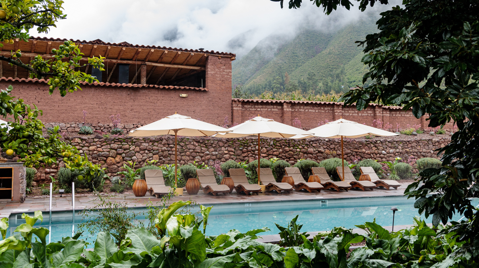 Infinity pool with mountain views and adobe walls at Explora Valle Sagrado in Peru's Sacred Valley near Cusco