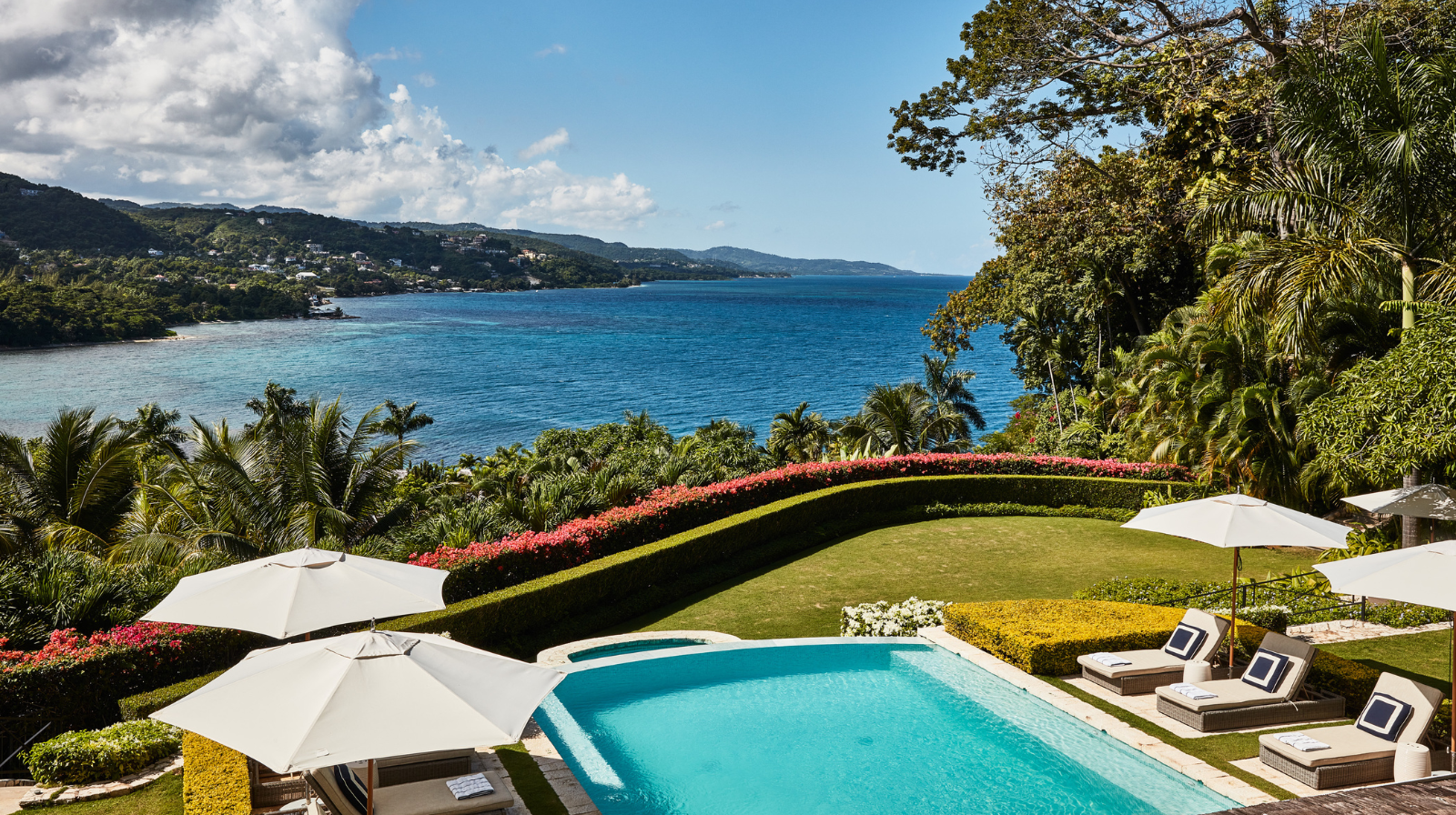 Infinity pool overlooking Caribbean Sea with manicured gardens at Round Hill Hotel and Villas Jamaica