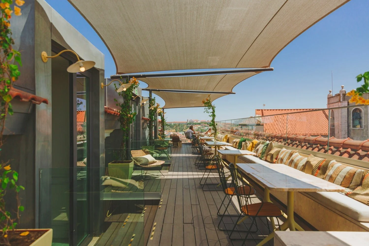 Lumi Rooftop Restaurant at The Lumiares Hotel & Spa in Lisbon, Portugal—stylish outdoor terrace with shaded seating, panoramic city views, modern design, and vibrant cushions, perfect for relaxed dining above Lisbon’s historic rooftops.