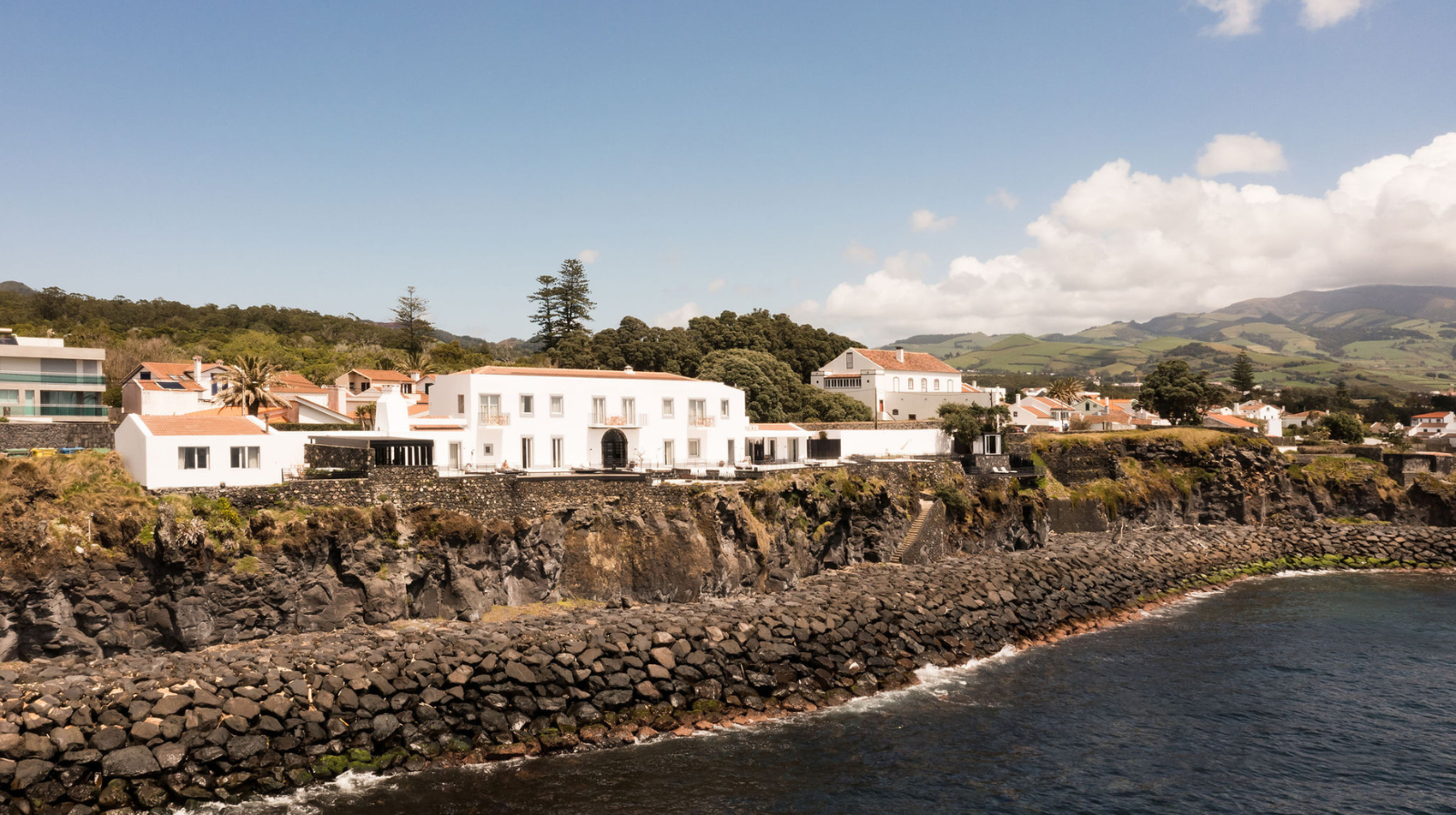 White coastal boutique hotel on volcanic cliffs overlooking the Atlantic Ocean in São Miguel, Azores, Portugal