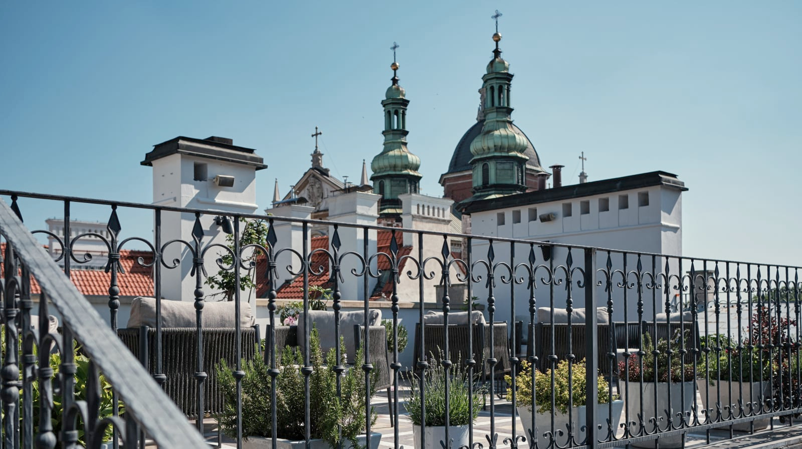 Rooftop terrace overlooking medieval church domes and historic architecture in Krakow's old town from Hotel Copernicus