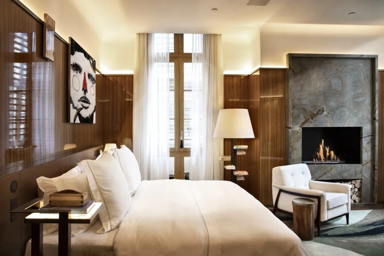 Elegant luxury hotel room at Rosewood São Paulo in Brazil, featuring modern art, wood-paneled walls, cozy fireplace, and designer furnishings—perfect for travelers seeking upscale accommodations in central São Paulo.