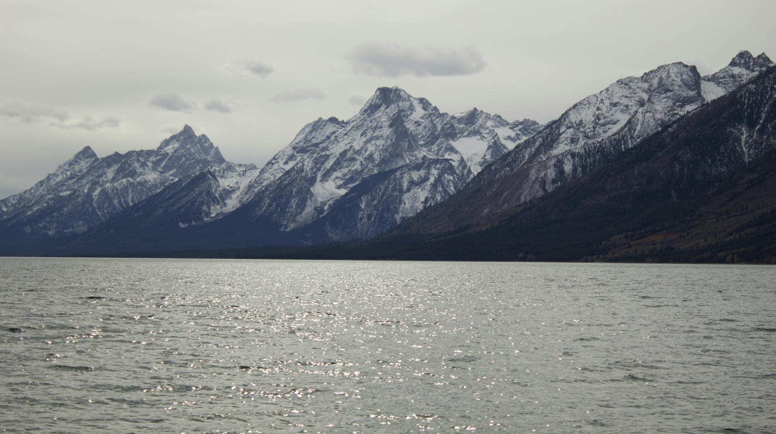Grand Teton mountain range covered in snow viewed across lake in Jackson Hole Wyoming winter