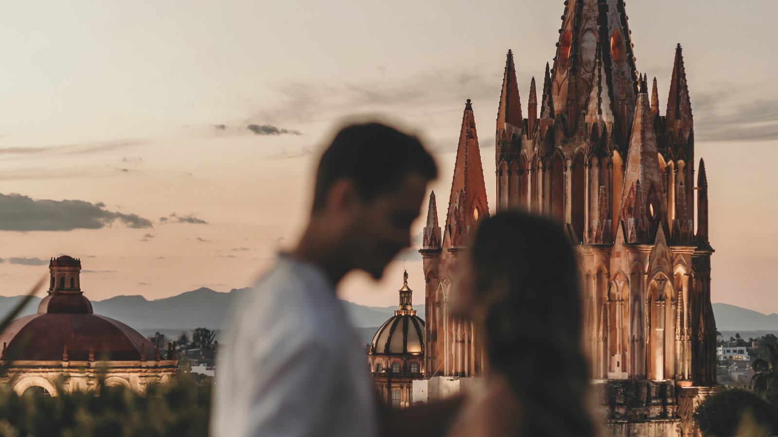 Couple at sunset with La Parroquia Gothic church in San Miguel de Allende, Mexico