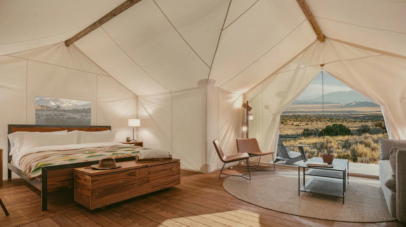 Minimalist luxury tent suite with king bed and desert canyon views in Moab, Utah near Arches National Park