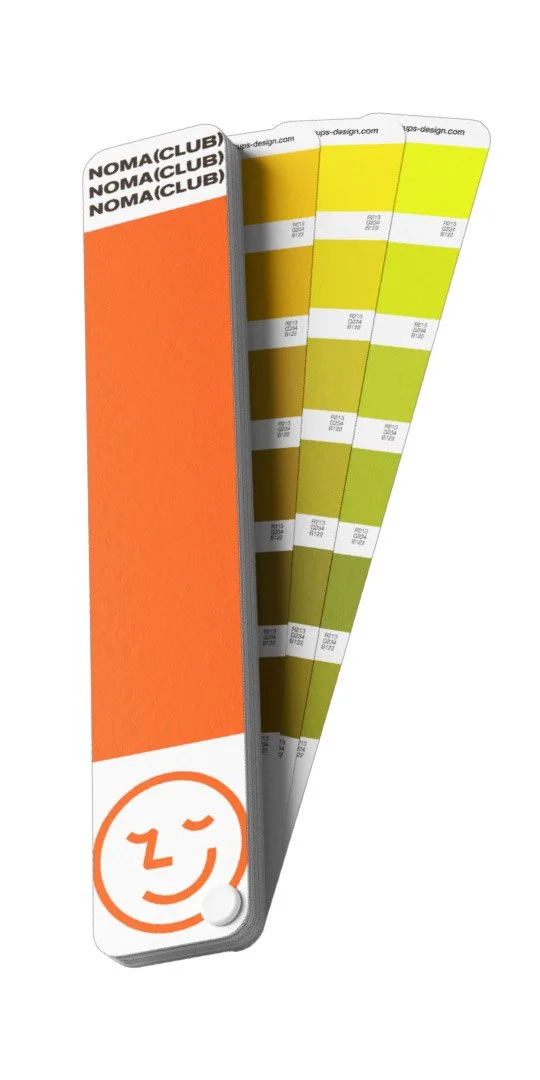 Color swatch sample with a Nomad Club label at the top and an orange section with a smiley face icon at the bottom.