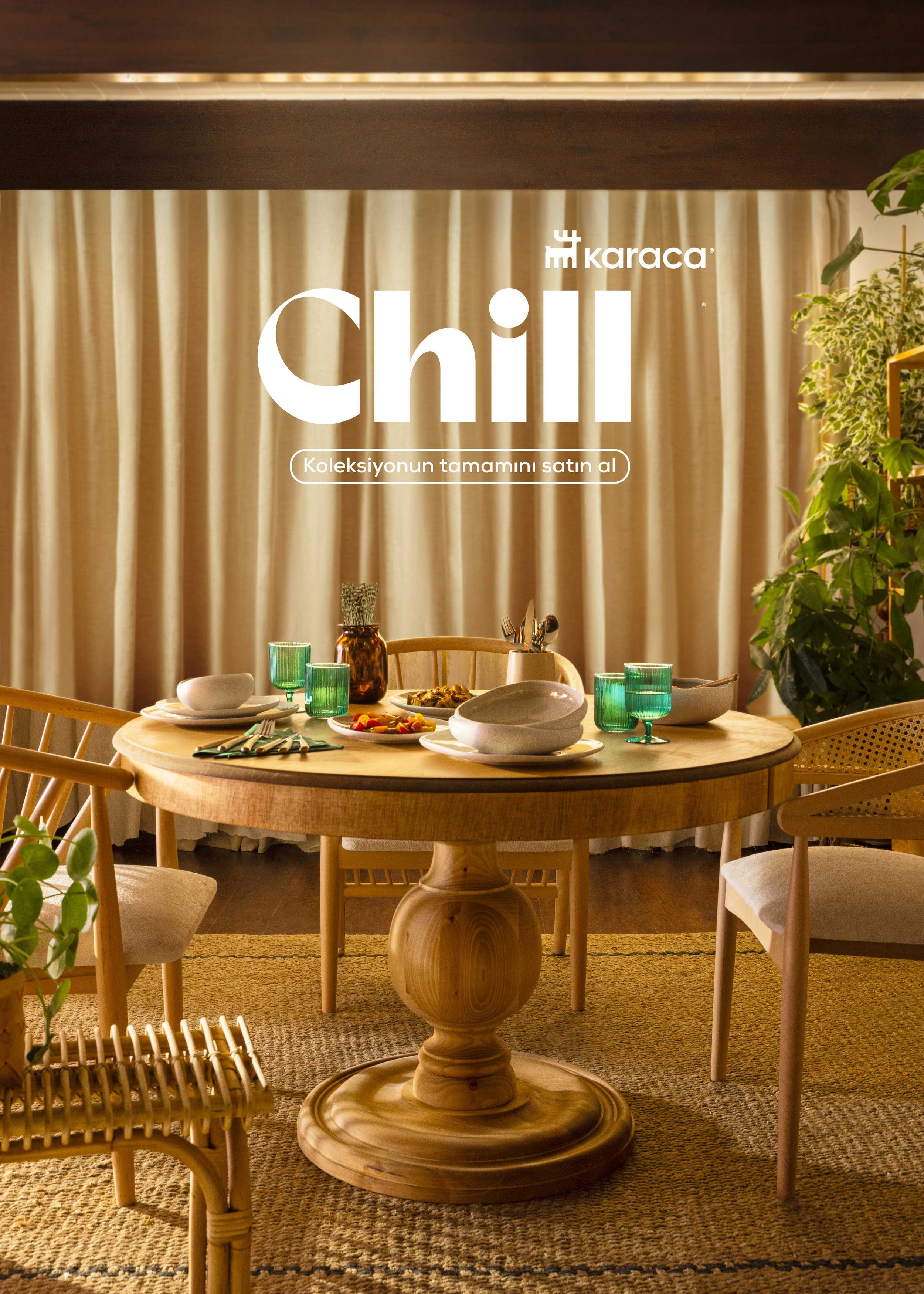 A dining table set with plates, bowls, glasses, and utensils, surrounded by wooden chairs, in a room with beige curtains and potted plants.