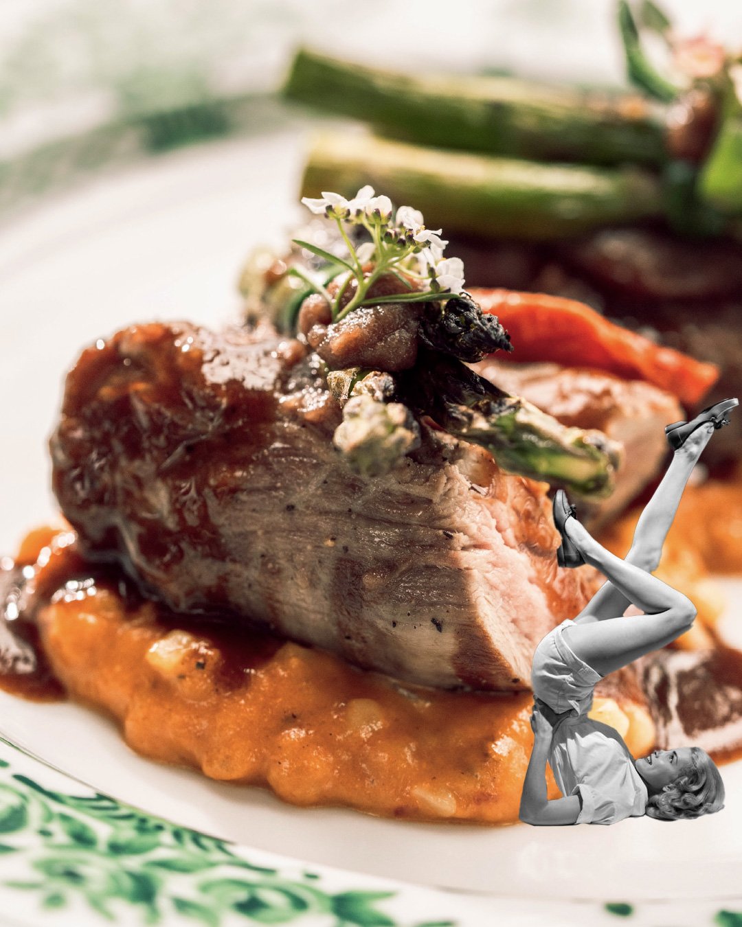 A gourmet dish with a large piece of meat on a bed of mashed vegetables or sauce, topped with microgreens and edible flowers, with a woman in vintage clothing doing a handstand photo edited into the scene.