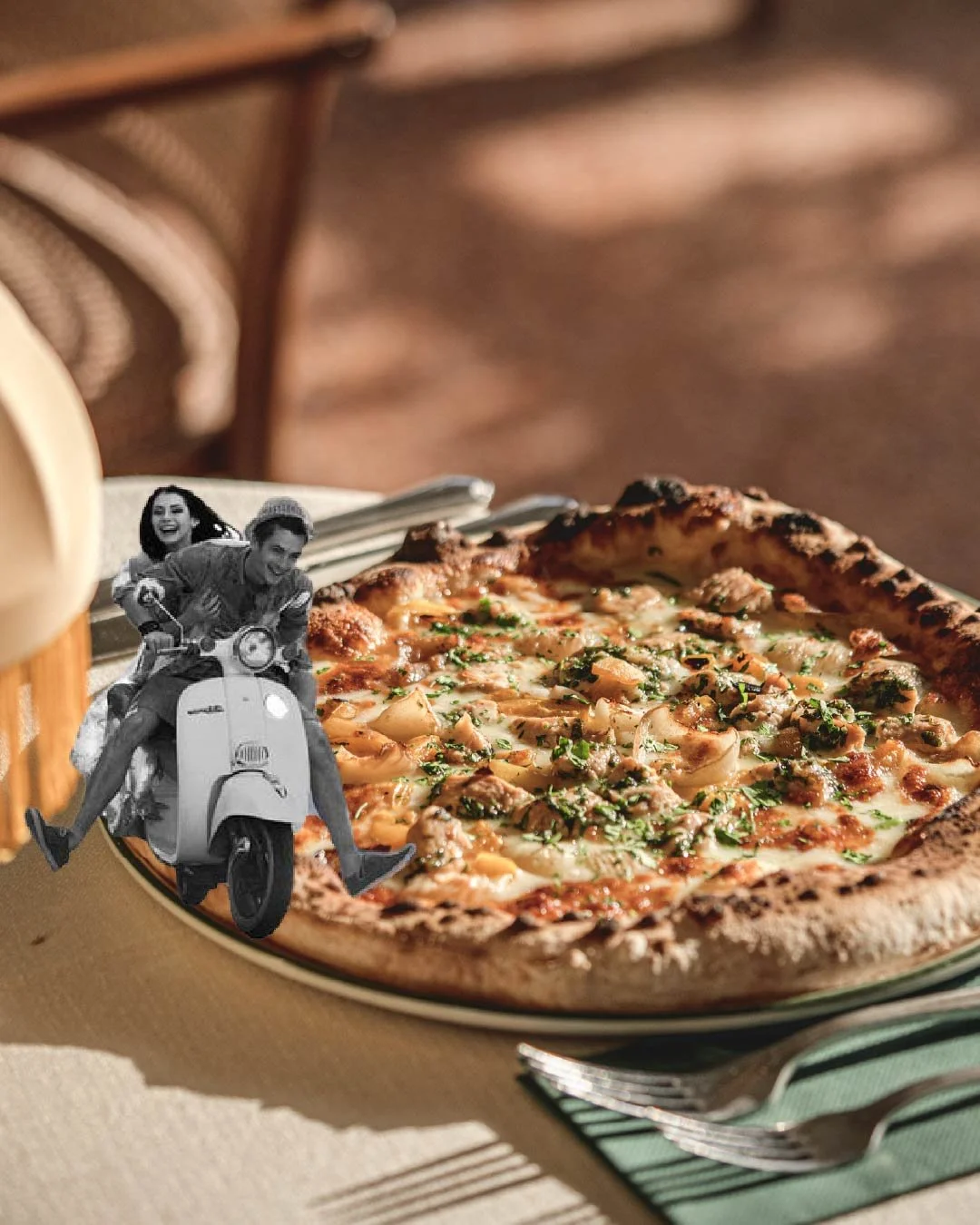 Close-up of a pizza with cheese, herbs, and meat toppings on a plate, with a fork beside it, and a black-and-white photo of a woman and a man riding a scooter attached in the foreground.