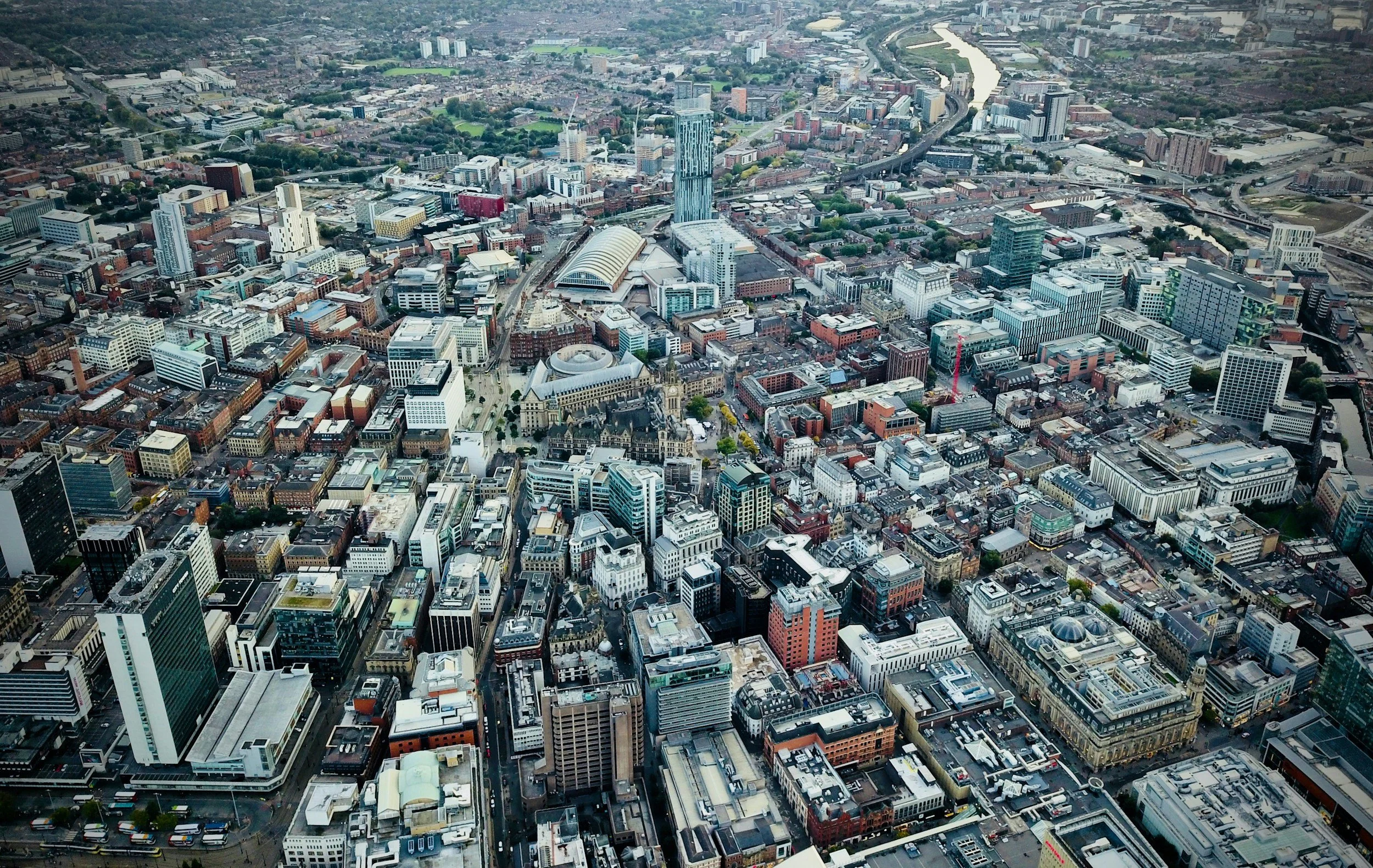Aerial view of Manchester, with various tall buildings and the Hilton hotel visible in the mid background.