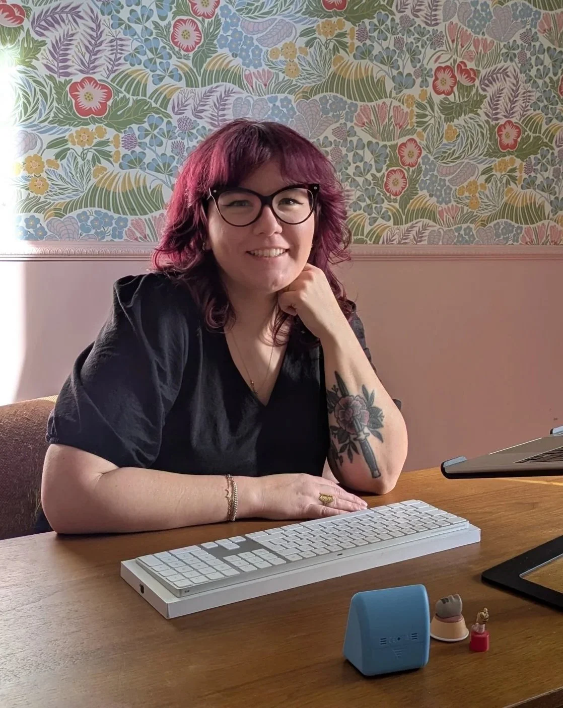 amélie hennequin, copywriter emailing, cheveux violets, robe noire, assise à un bureau