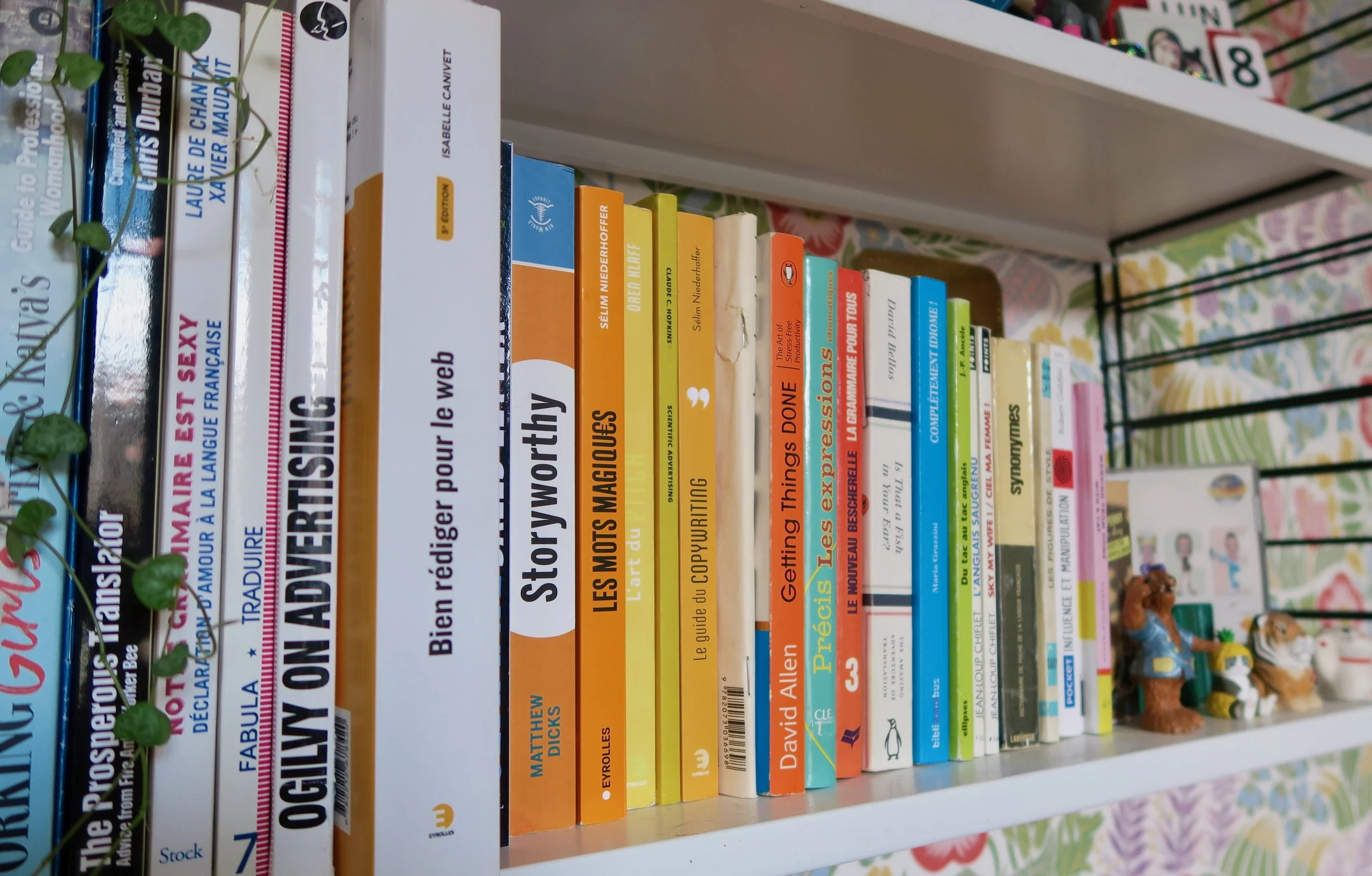 colorful books about copywriting on a wall shelf