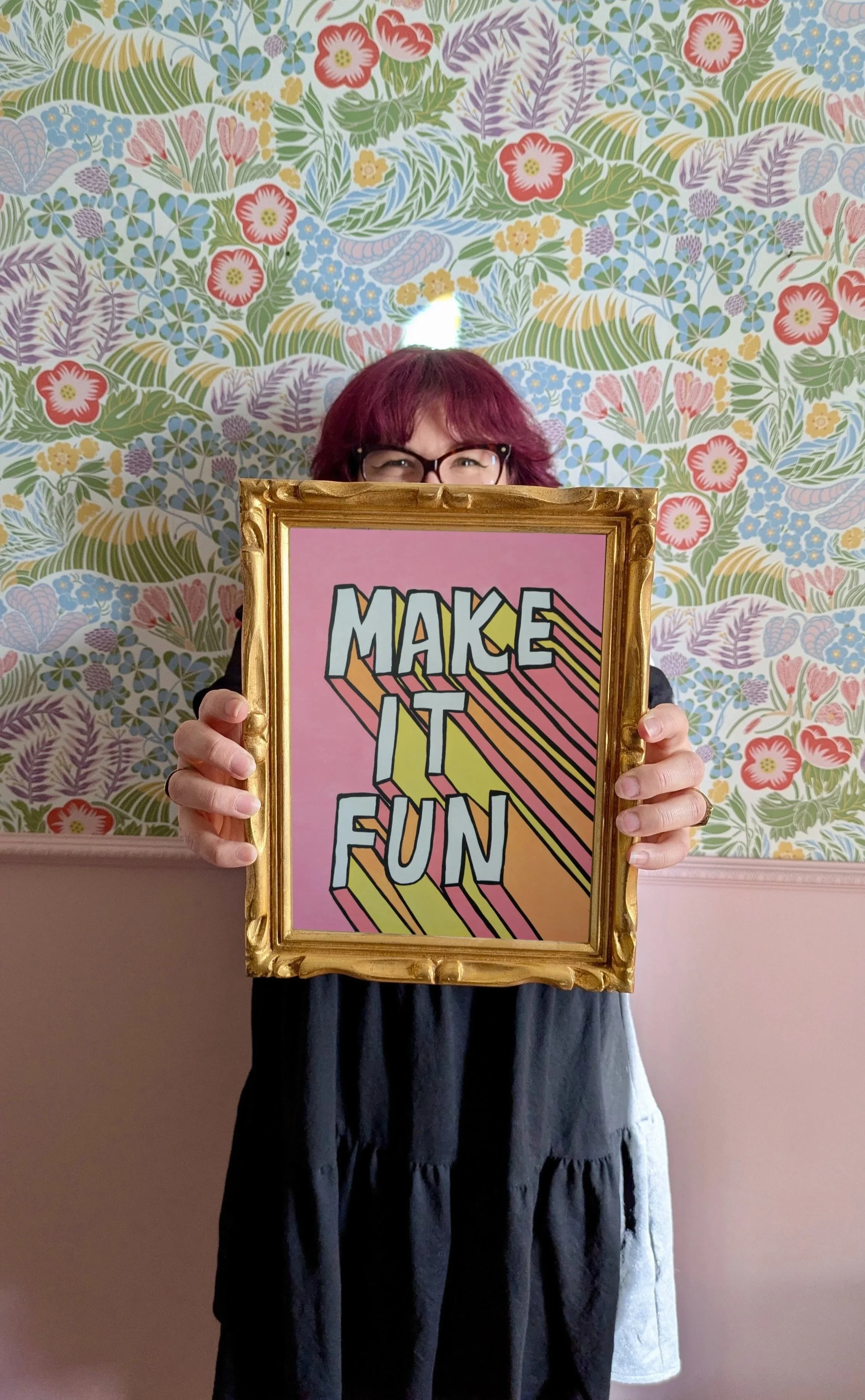 Amélie Hennequin, copywriter pour sites web, tenant un tableau Make it fun coloré