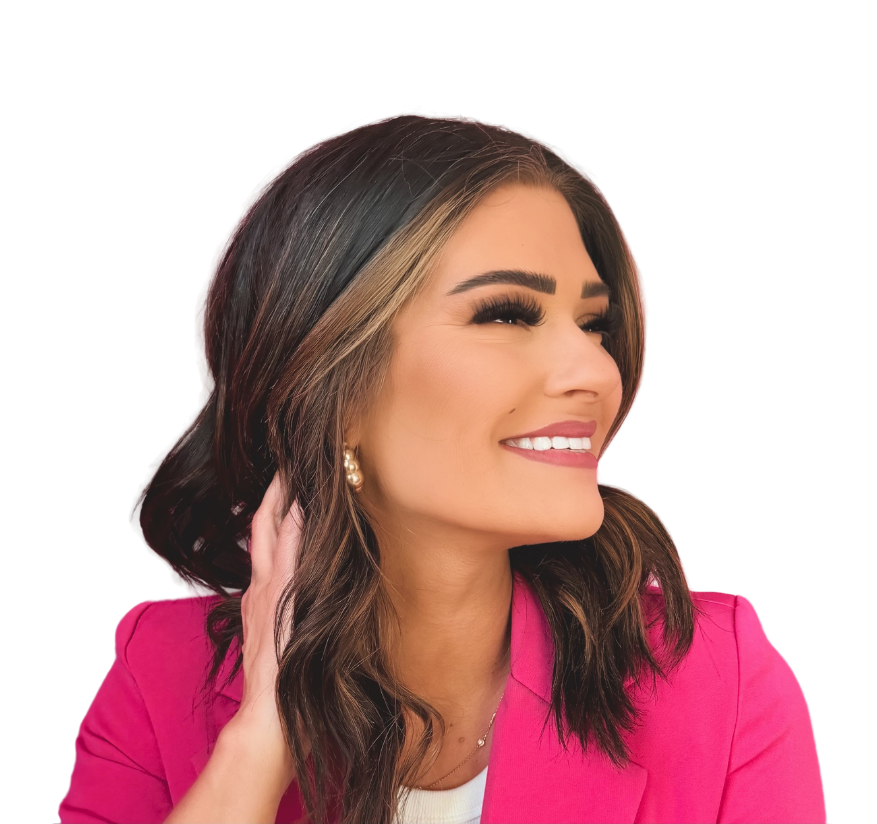 Portrait of a woman with long brown hair, smiling, dressed in a pink blazer, against a black background.