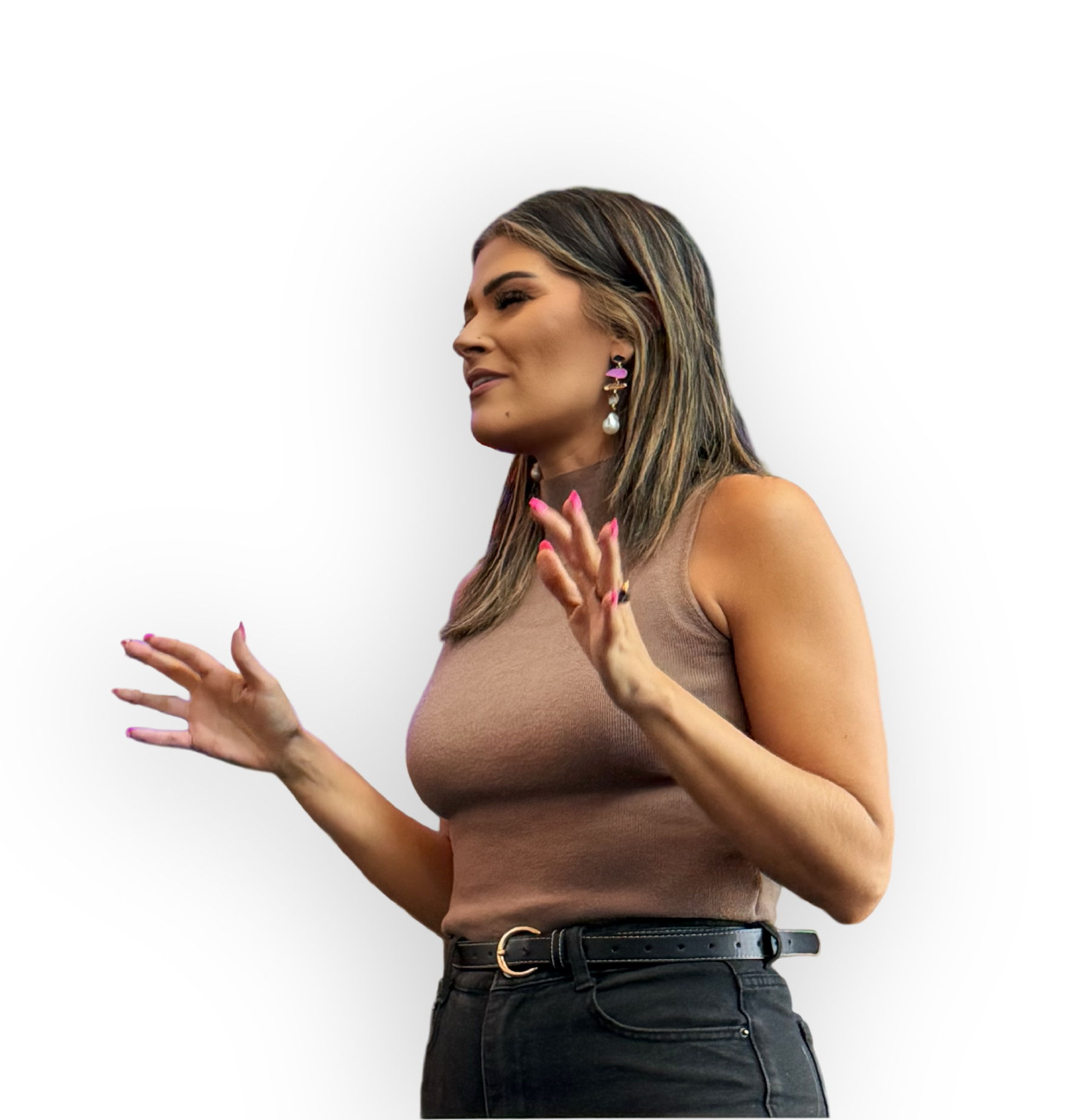A woman with long, highlighted hair, wearing a beige sleeveless top and black high-waisted jeans, is gesturing with her hands against a black background.