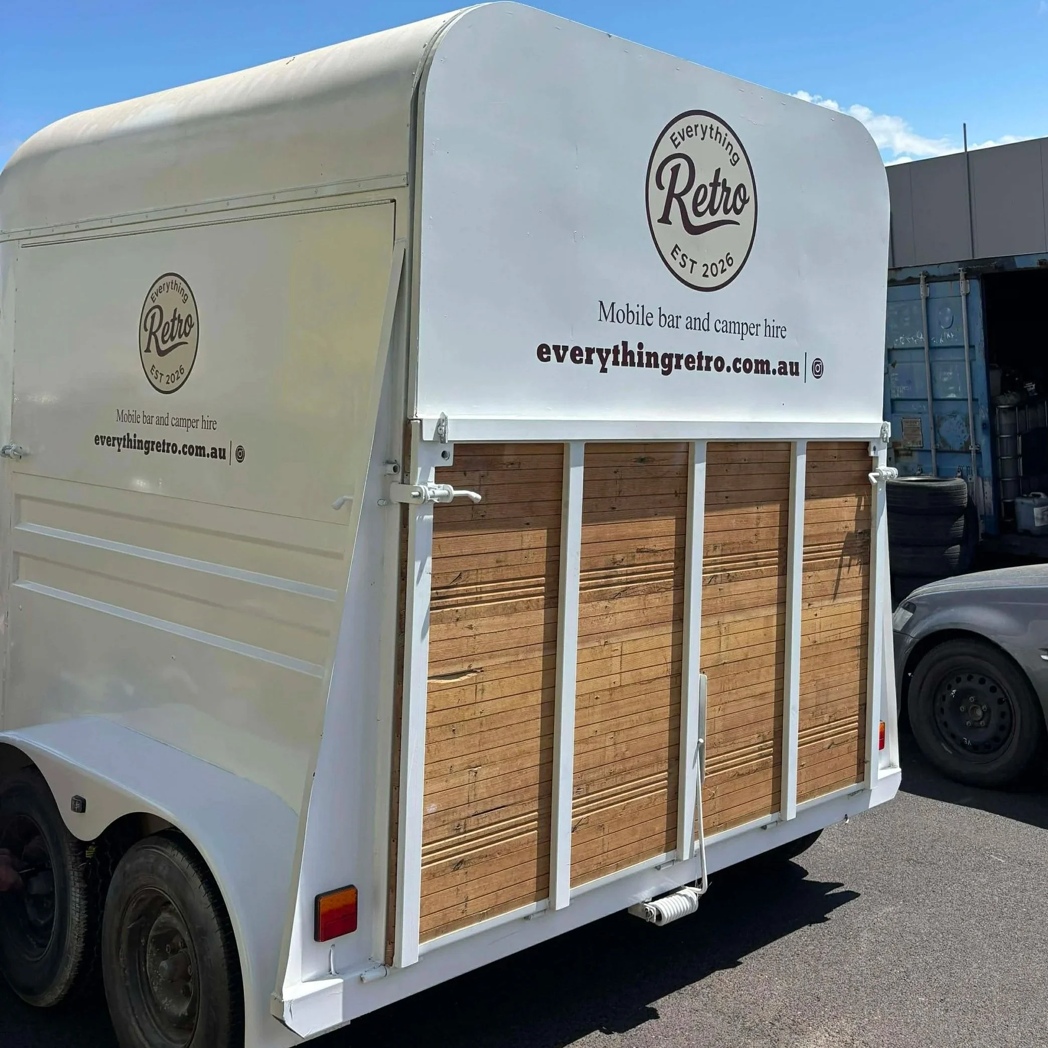 White mobile bar trailer with wooden accents, advertising 'Everything Retro' for mobile bar and camper hire, with website 'everythingretro.com.au'.