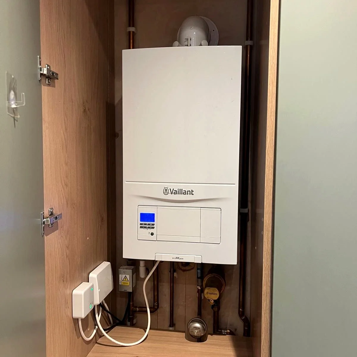 Vaillant boiler installation inside a cupboard, ready for servicing and maintenance