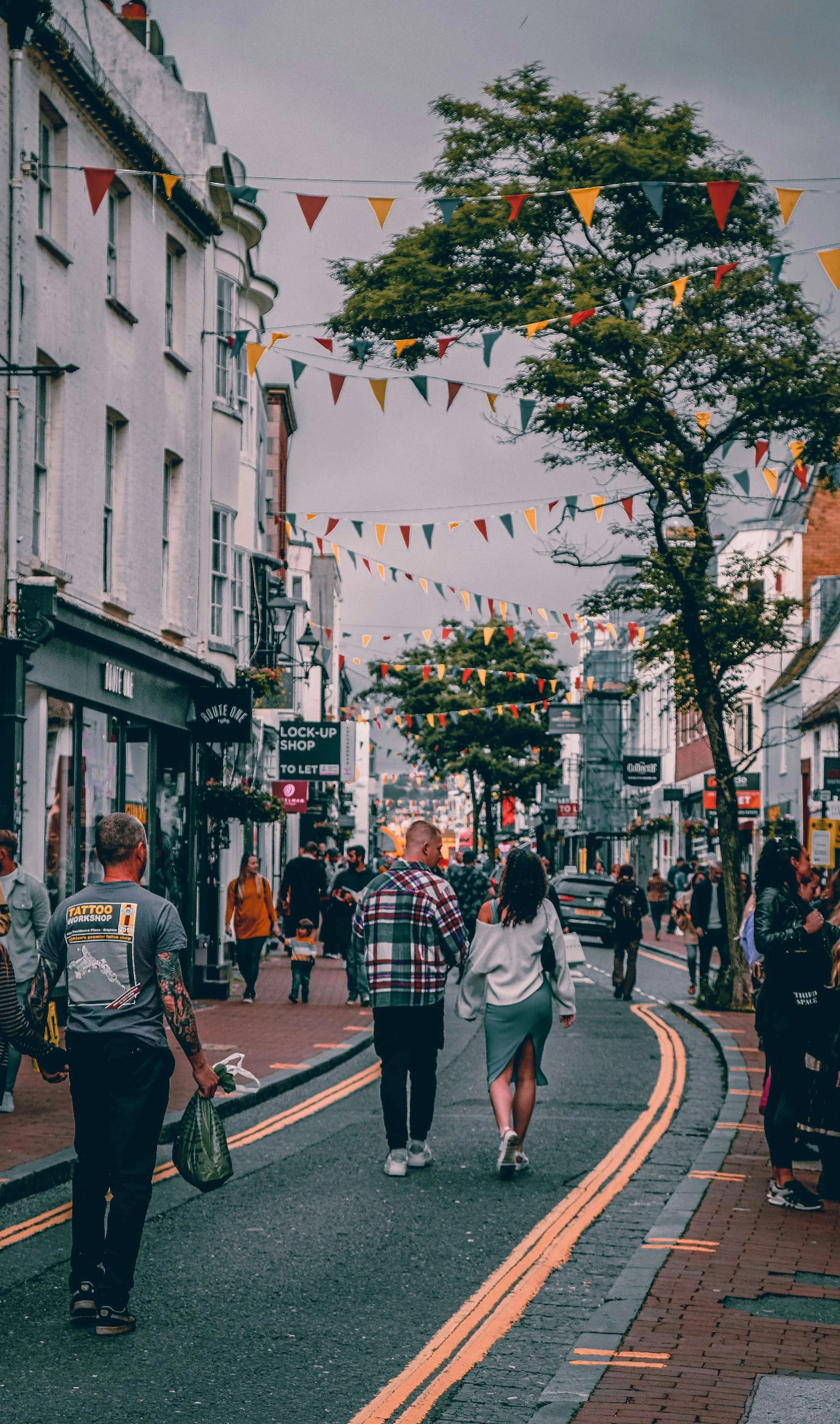 Brighton high street with local residents walking beneath colourful bunting