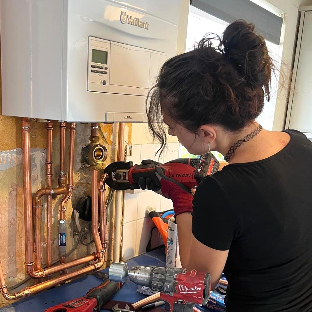 Lola working on a boiler installation – family-run Brighton plumbing and heating team.