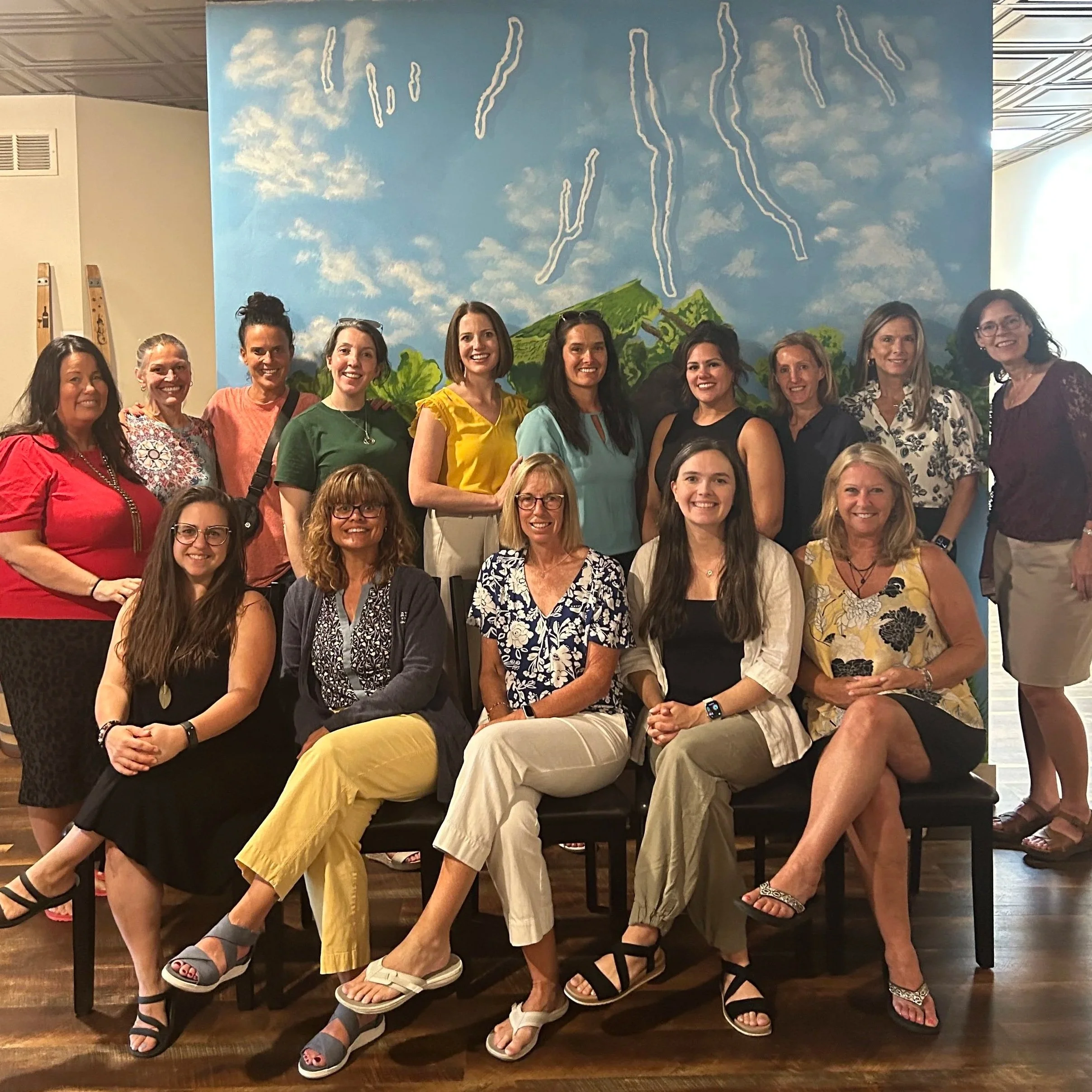 Members of PWFL in front of a mural of the Finger Lakes