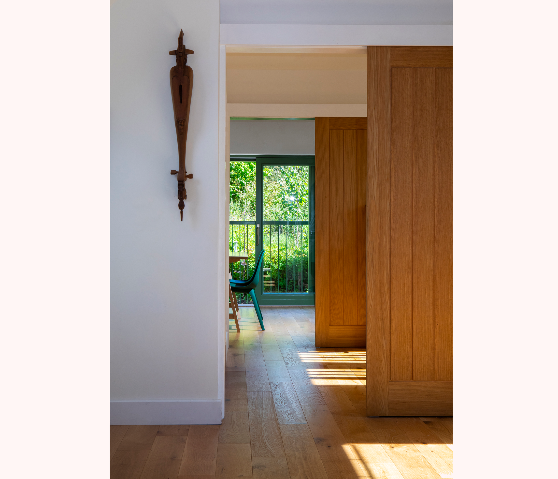 View of light filled rooms with sliding doors and garden in background