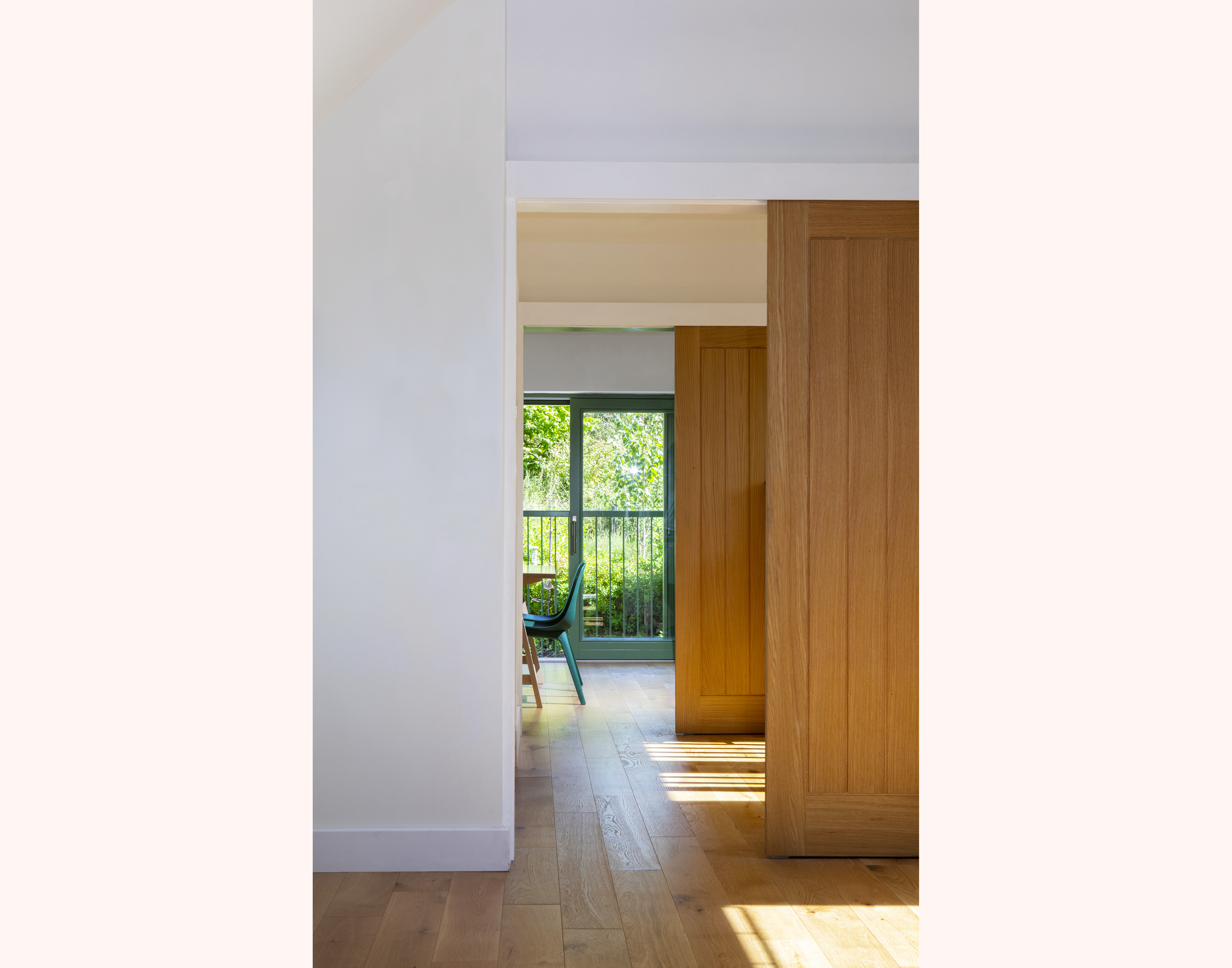 View of light filled rooms with sliding doors and garden in background