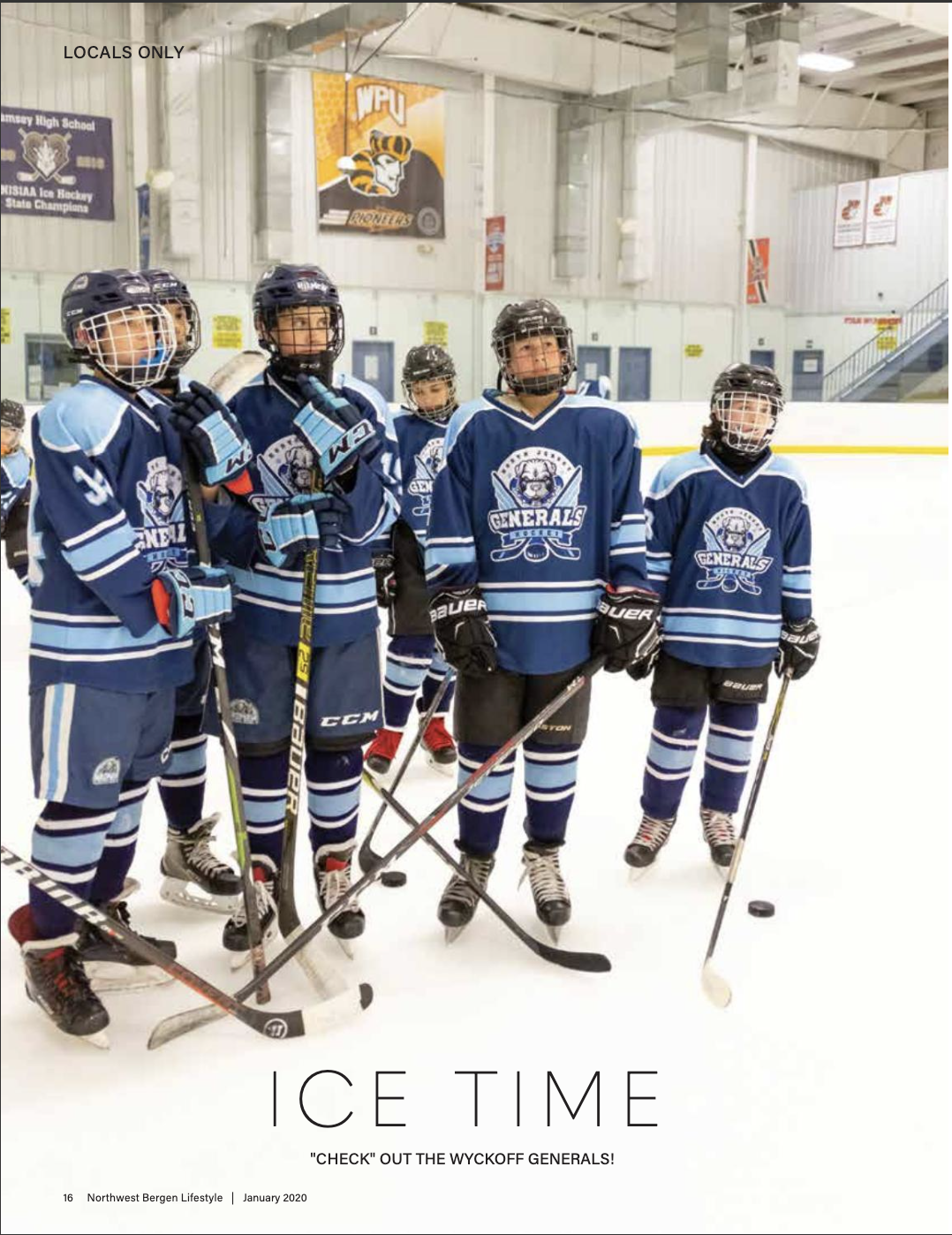 NJ Generals Youth hockey team in blue jerseys and helmets standing on ice rink, holding hockey sticks and focused on coaching instructions.