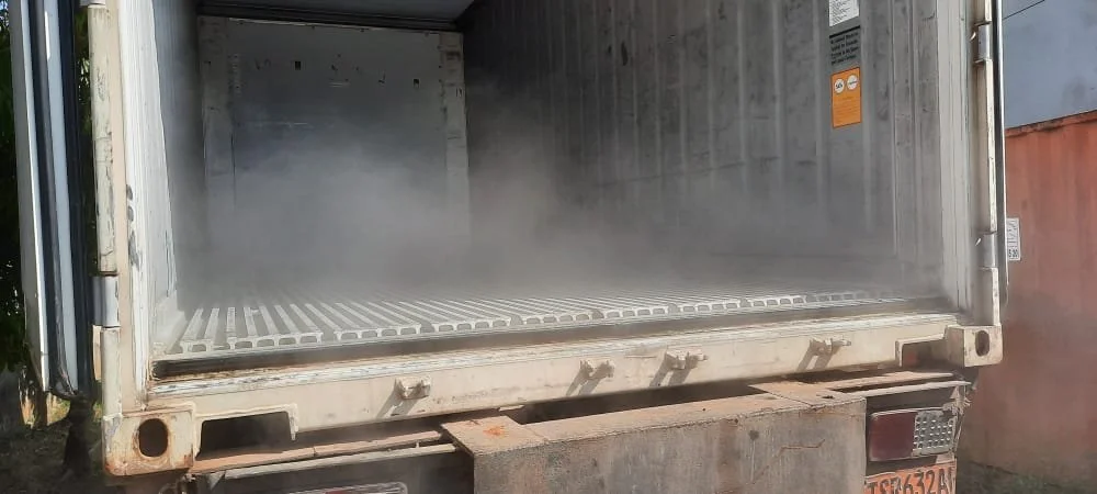 The inside of an empty refrigerated truck with some fog or vapor near the opening for fresh katemfe arils shipment worldwide.