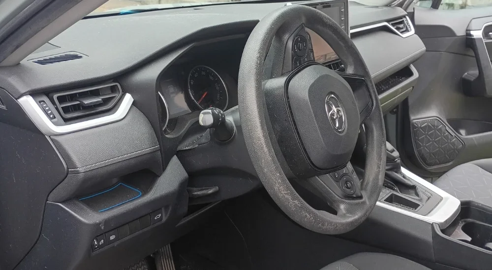 Interior of a modern car showing the steering wheel, dashboard, gear shift, and center console.